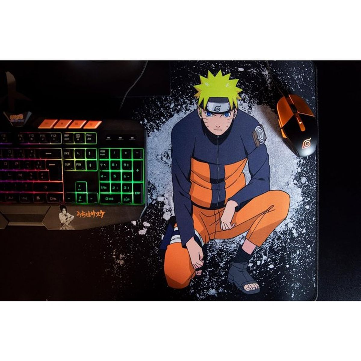 Naruto, un personaje de anime, se agacha junto a un teclado y un ratón sobre una alfombrilla negra.