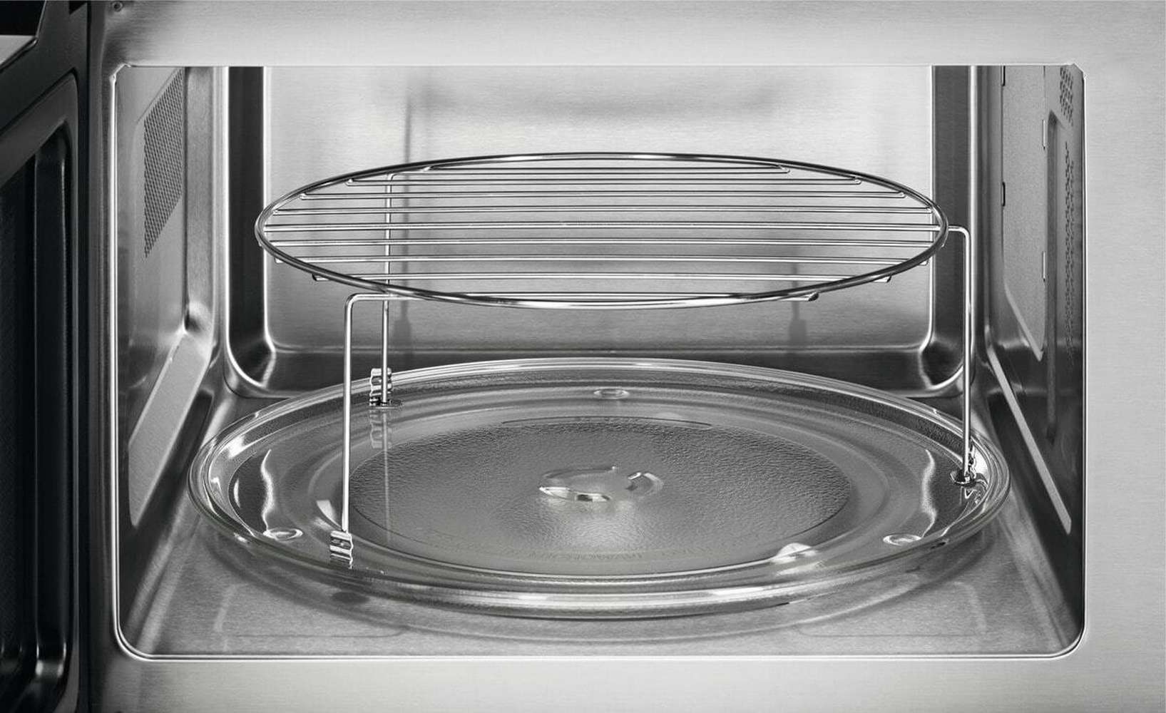 Vista interior de un microondas con plato giratorio de cristal y rejilla.