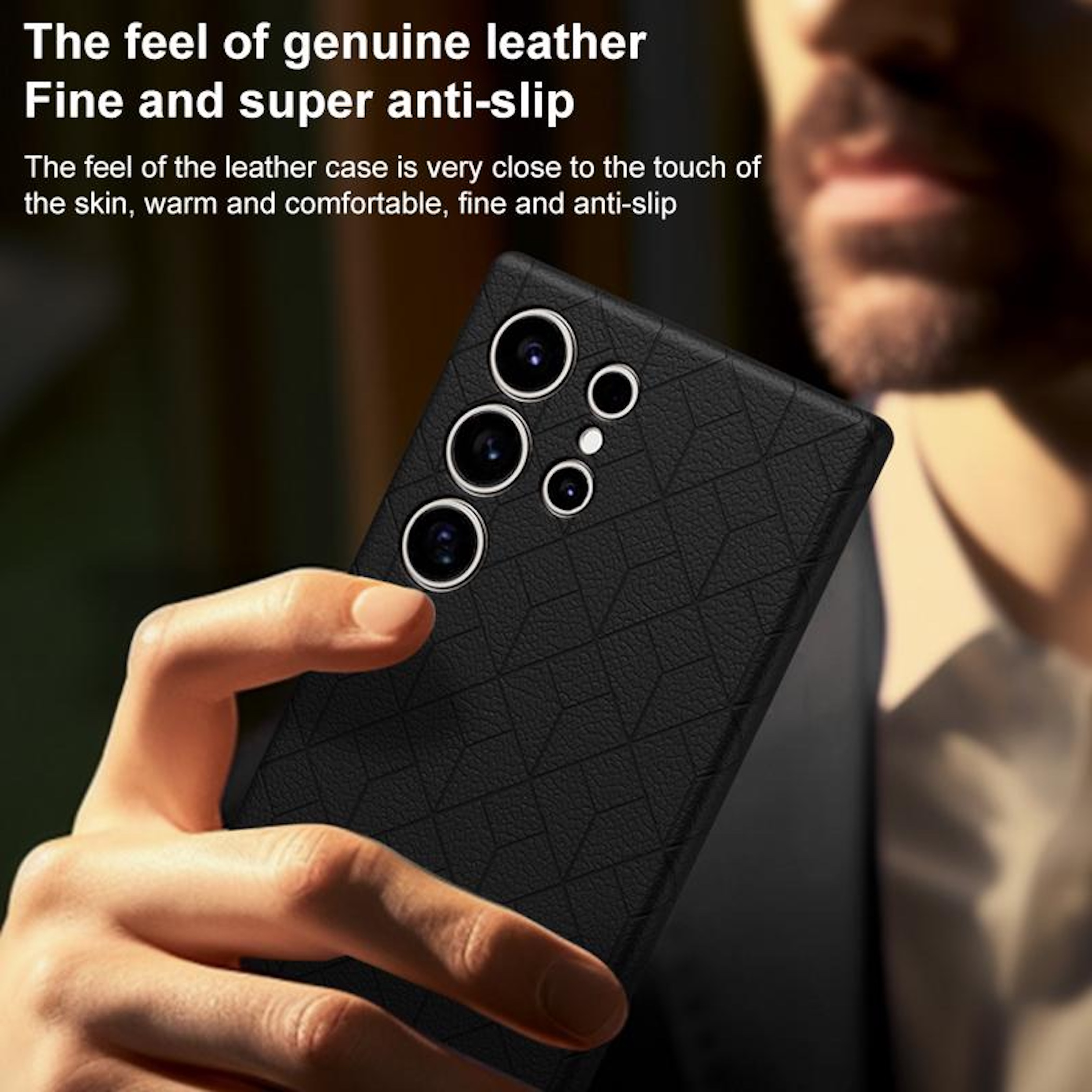 Schwarzes Handy mit Lederhülle, von einer Hand gehalten. Kameraobjektive sichtbar.