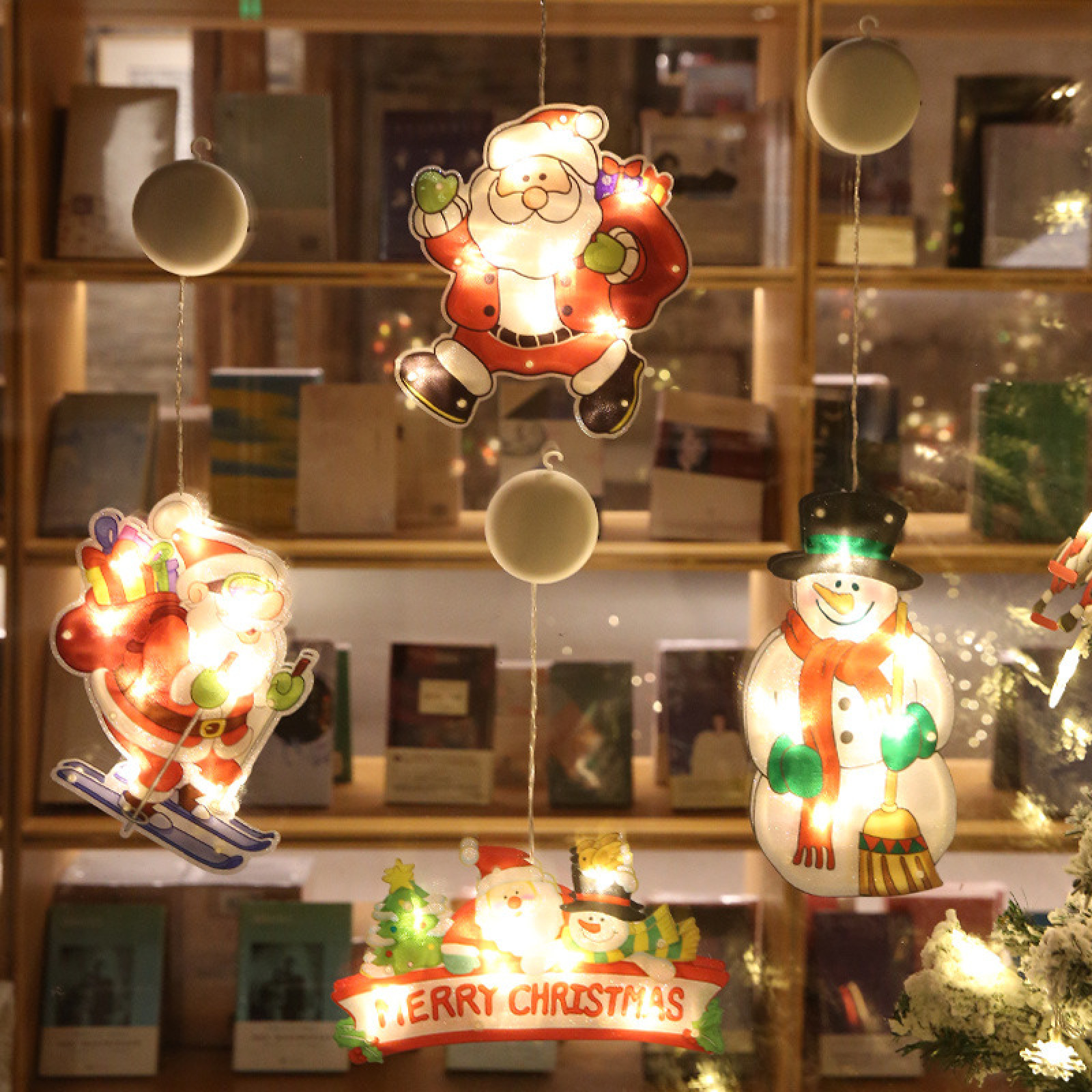 Weihnachtsdeko: Hängende Lichter von Weihnachtsmann, Schneemann und Schriftzug.