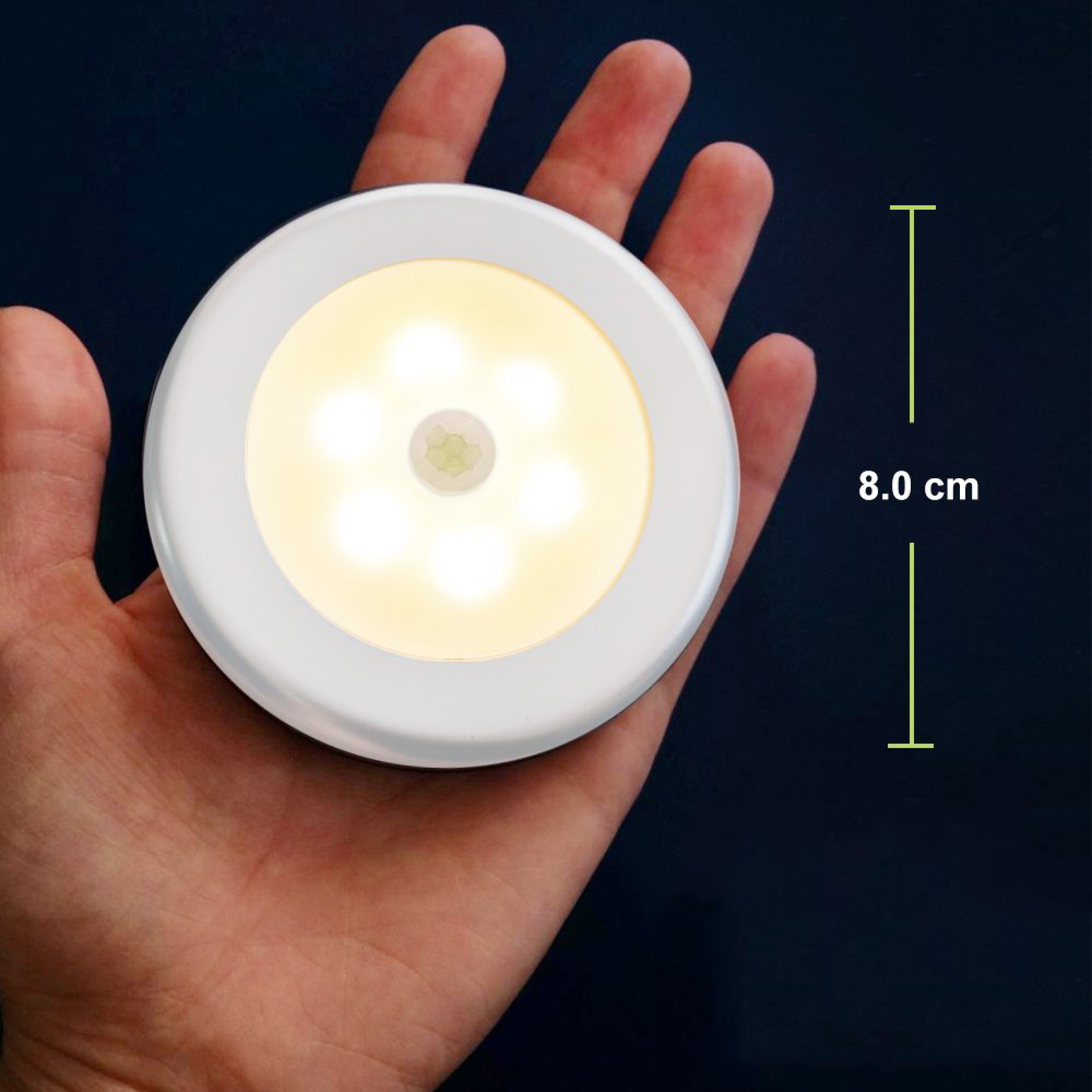 Eine Hand hält eine runde weiße Lampe mit sechs LEDs und einem Sensor.