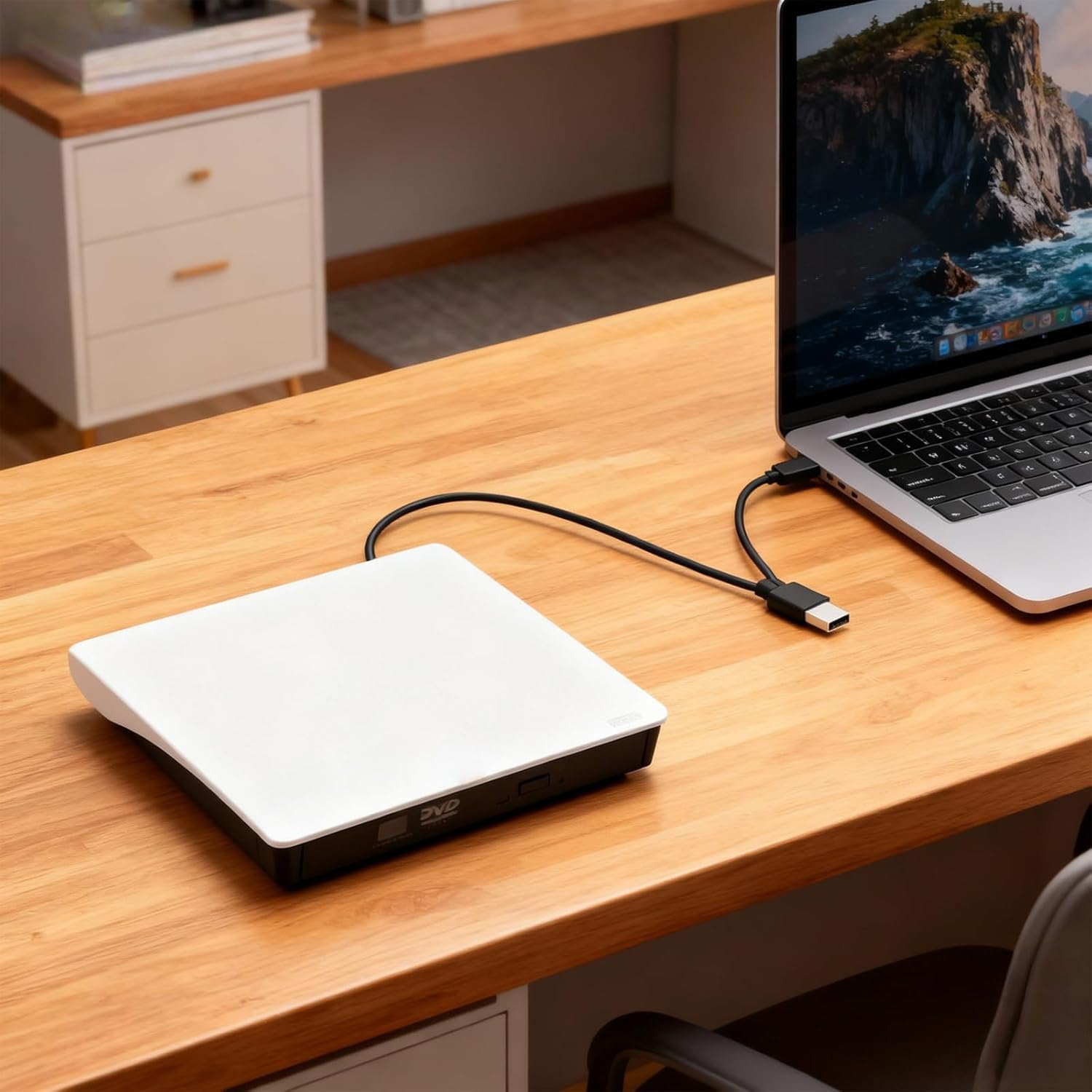 Ein weißes externes DVD-Laufwerk ist über USB mit einem Laptop verbunden.