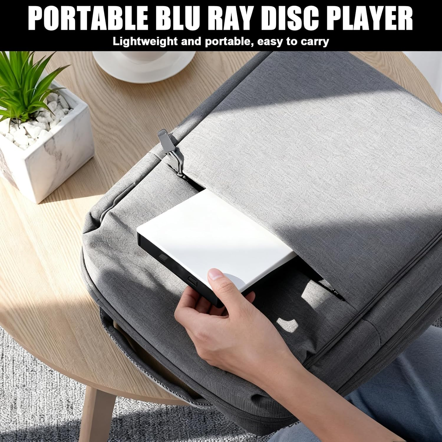 Eine Person legt einen weißen Blu-ray-Player in eine graue Tasche.