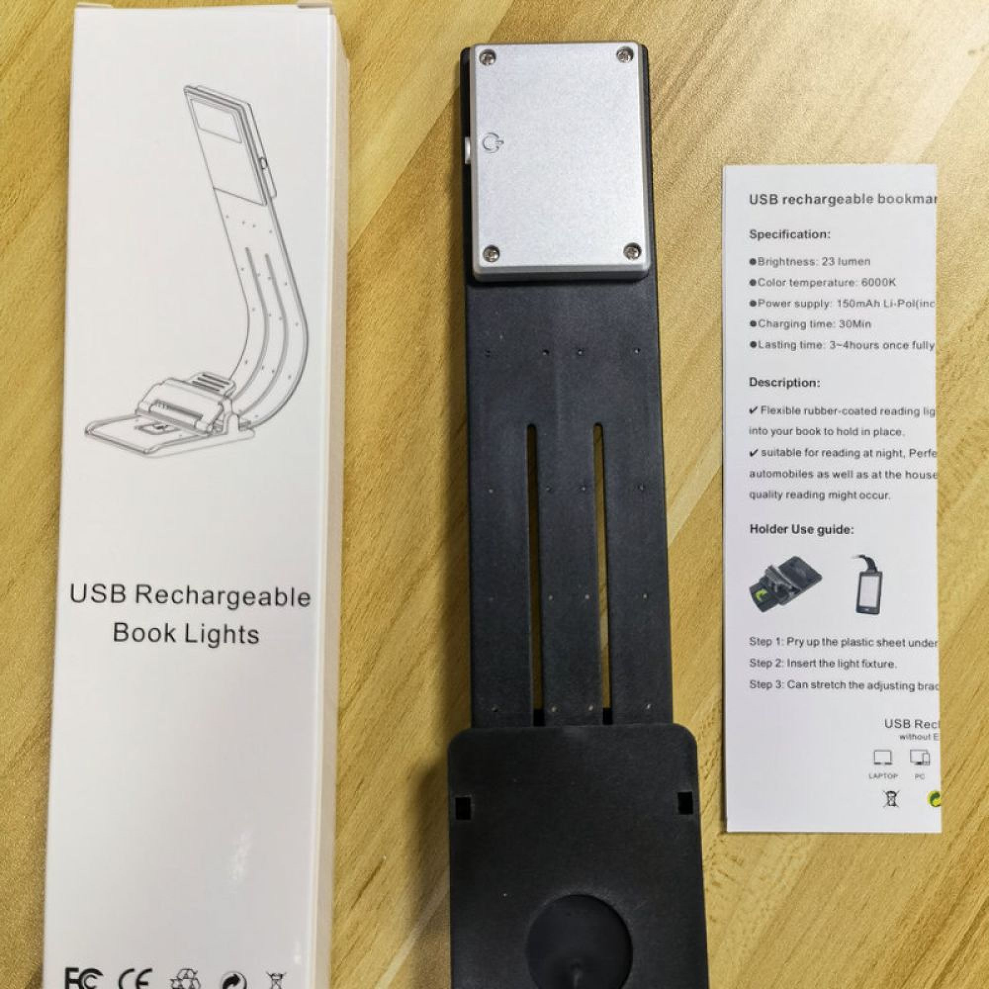 Ein USB-wiederaufladbares Buchlicht mit flexibler Halterung liegt neben seiner Verpackung.