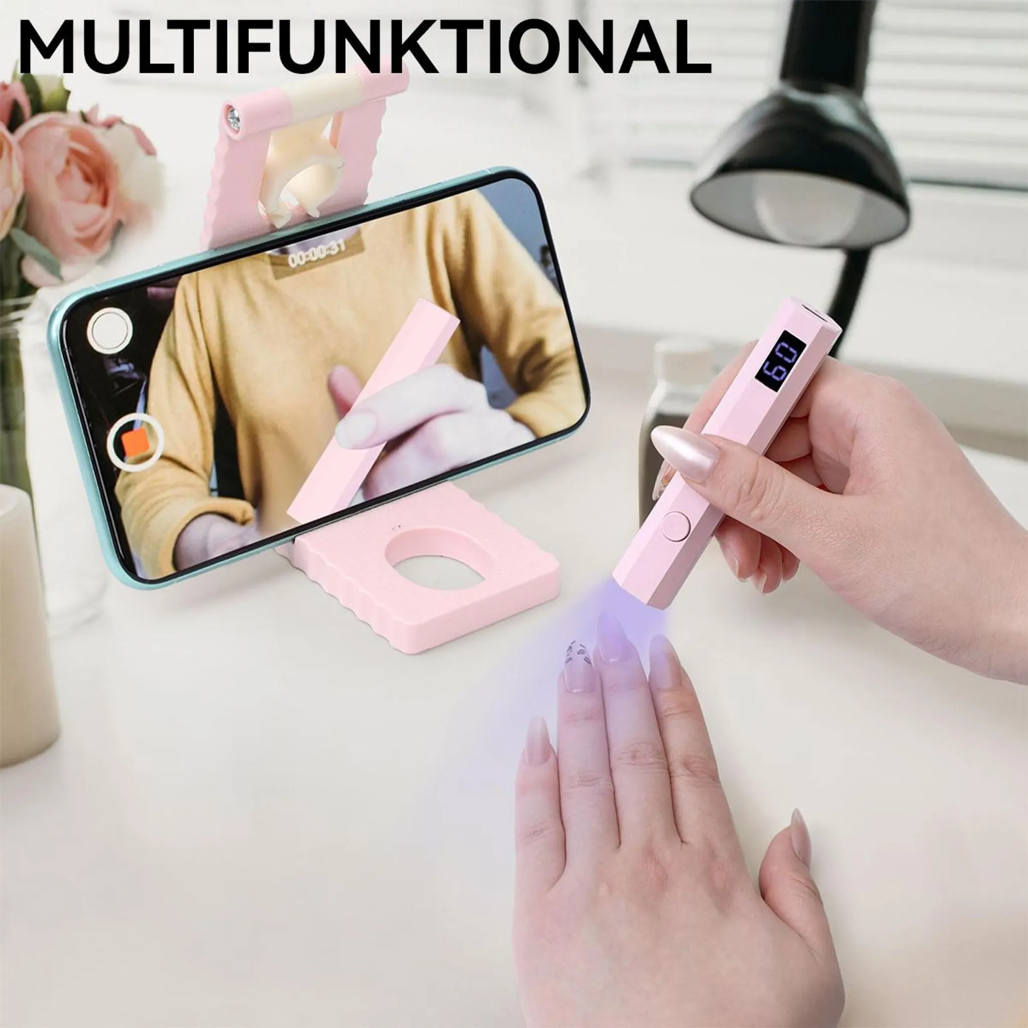 Person benutzt rosa UV-Lampe für Nägel, Handy im Ständer, Text MULTIFUNKTIONAL.
