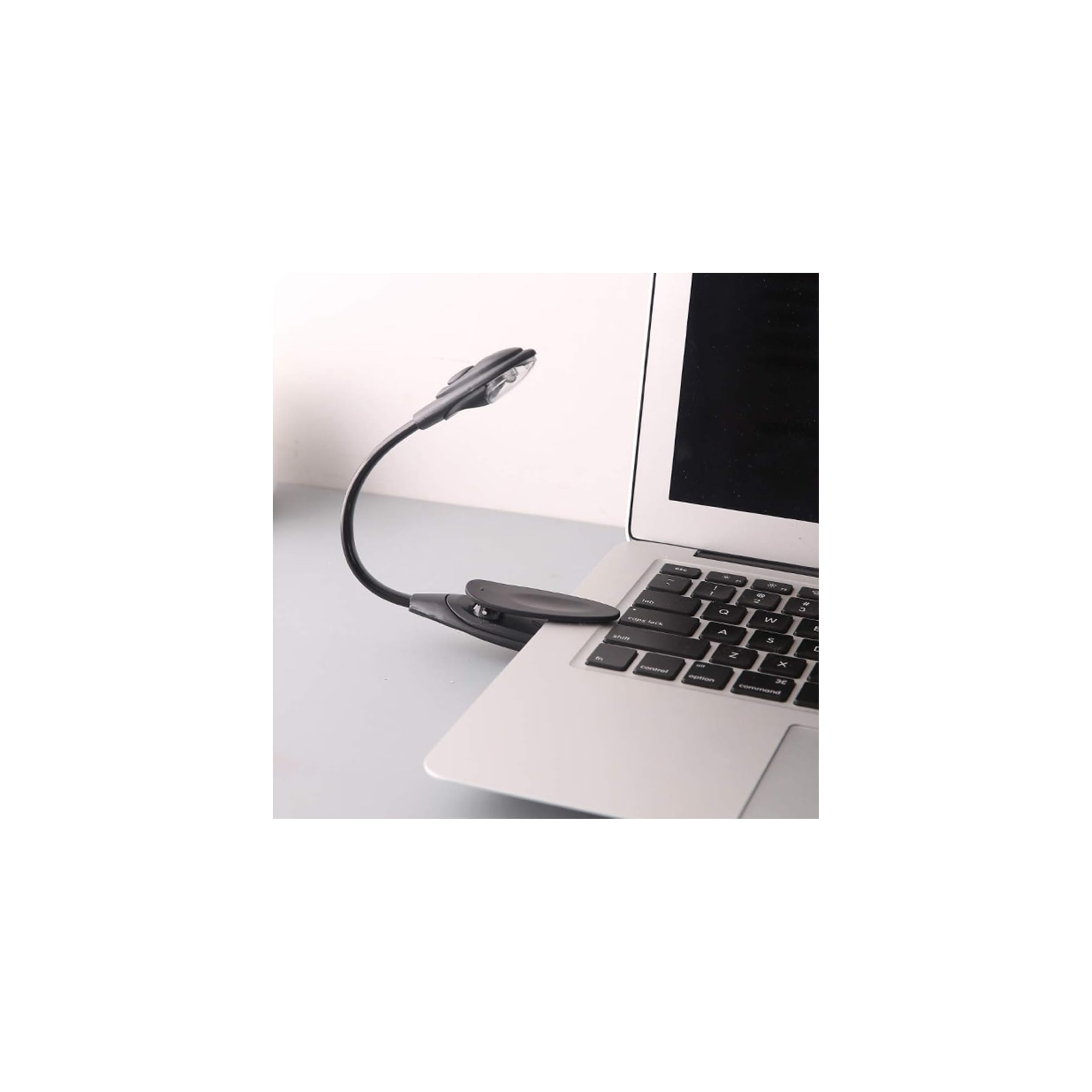Ein schwarzes USB-Klemmlicht ist an einem Laptop befestigt.