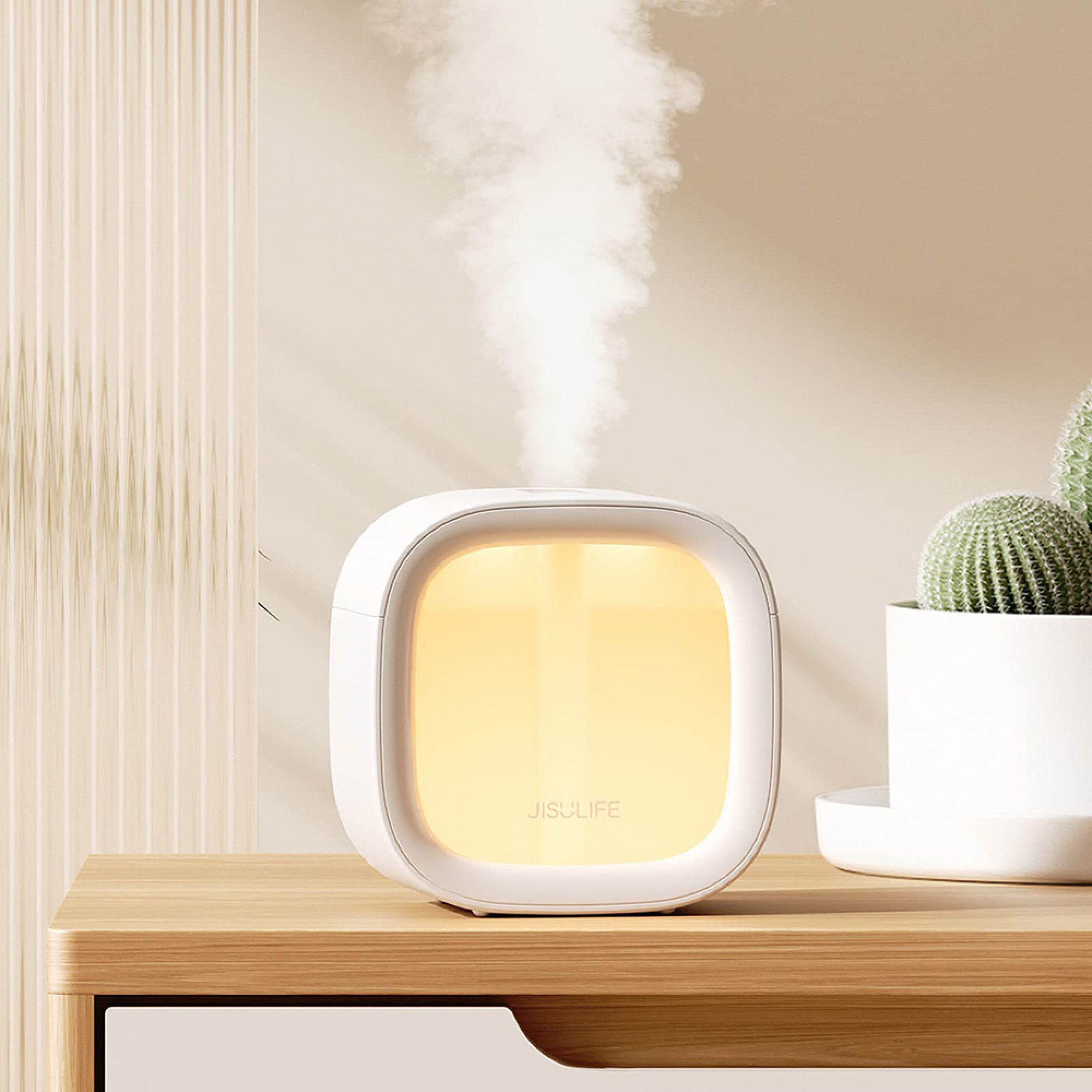 Ein weißer Diffusor gibt Dampf ab, mit einem gelben Licht dahinter. Daneben ein Kaktus.