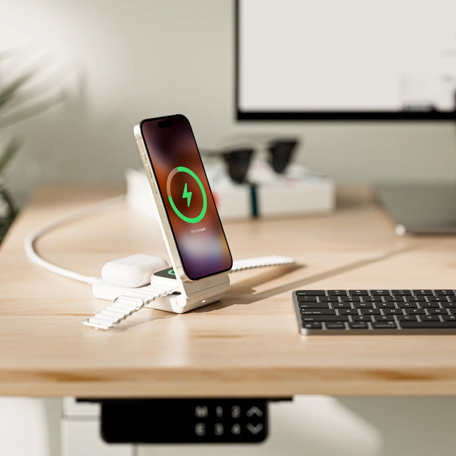 Ein Smartphone, eine Smartwatch und Ohrhörer auf einem Ladegerät.