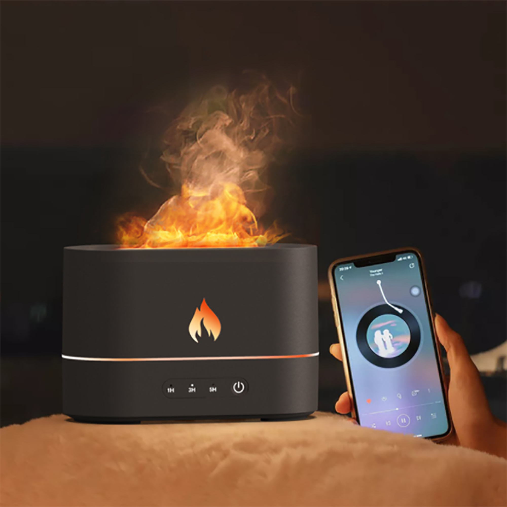 Ein schwarzer Diffusor mit Flammen-Effekt und ein Smartphone in der Hand.