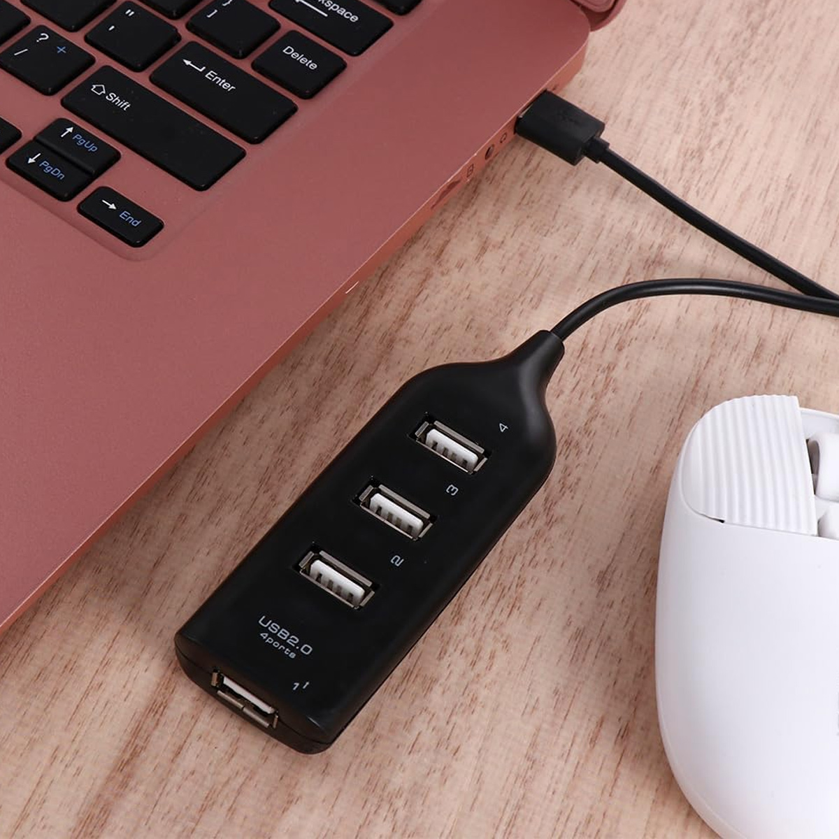 Schwarzer USB-Hub mit vier Anschlüssen, verbunden mit einem Laptop und einer Maus.
