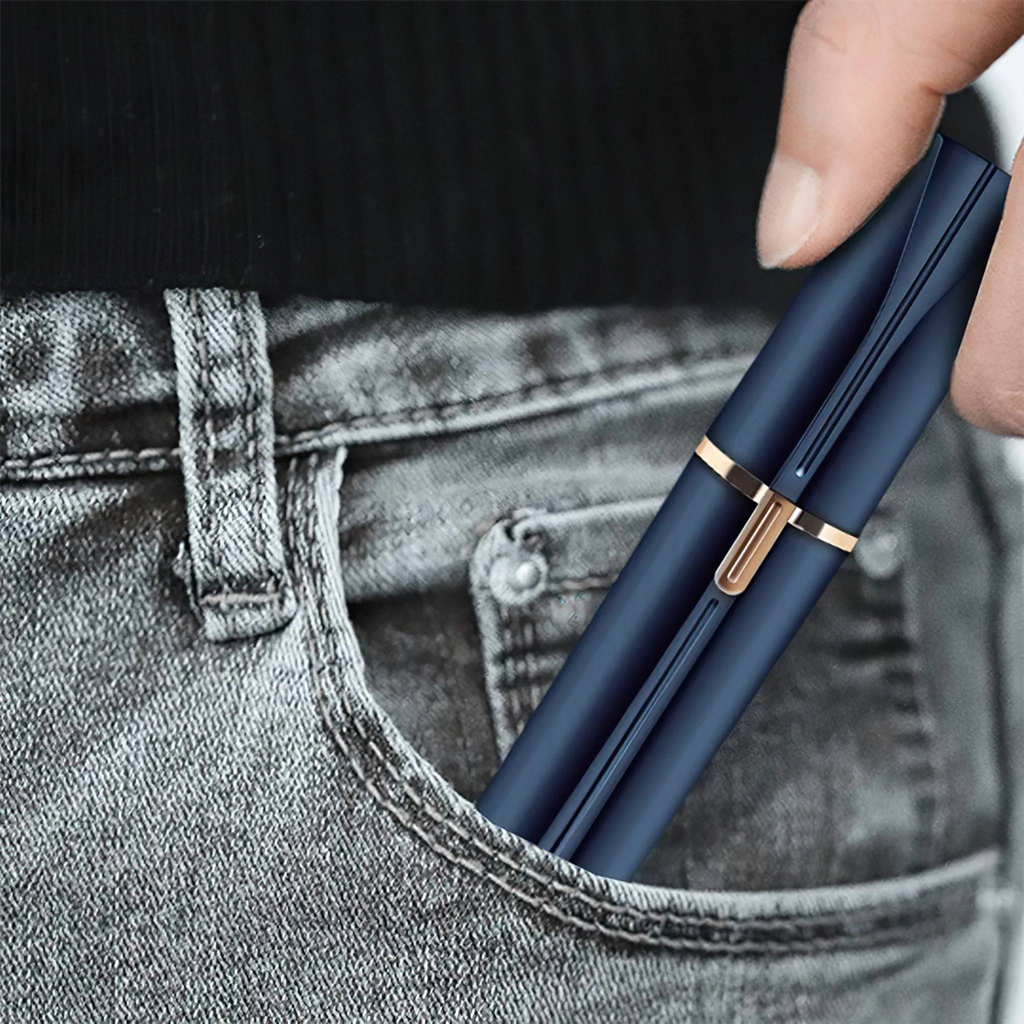 Dunkelblaues Objekt mit Goldakzenten steckt in Jeans-Tasche.
