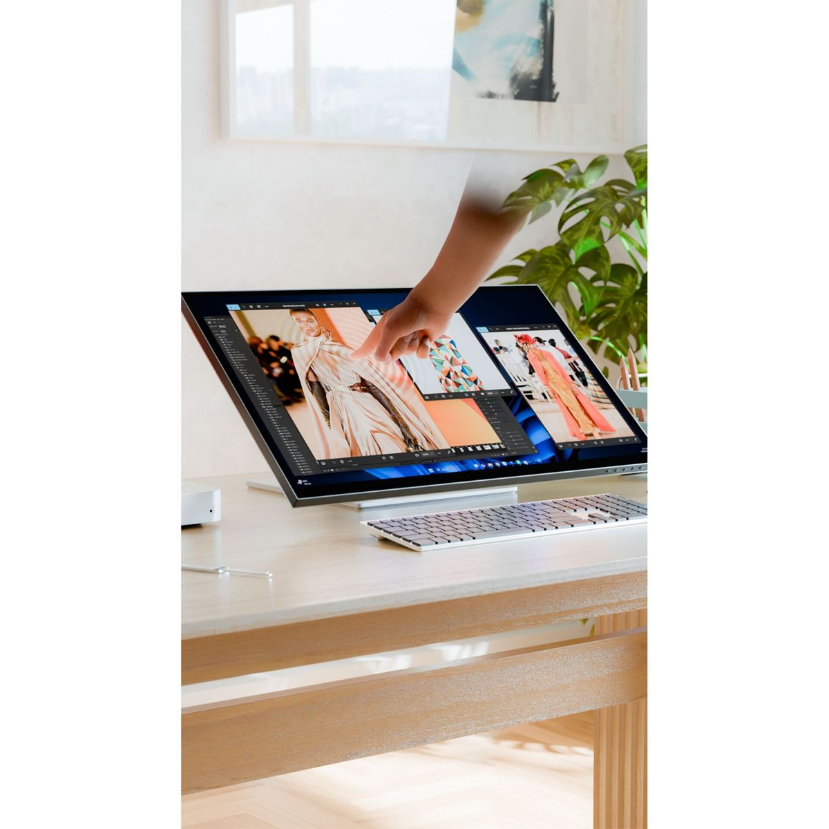 Una mano tocca lo schermo di un computer che mostra immagini di moda.
