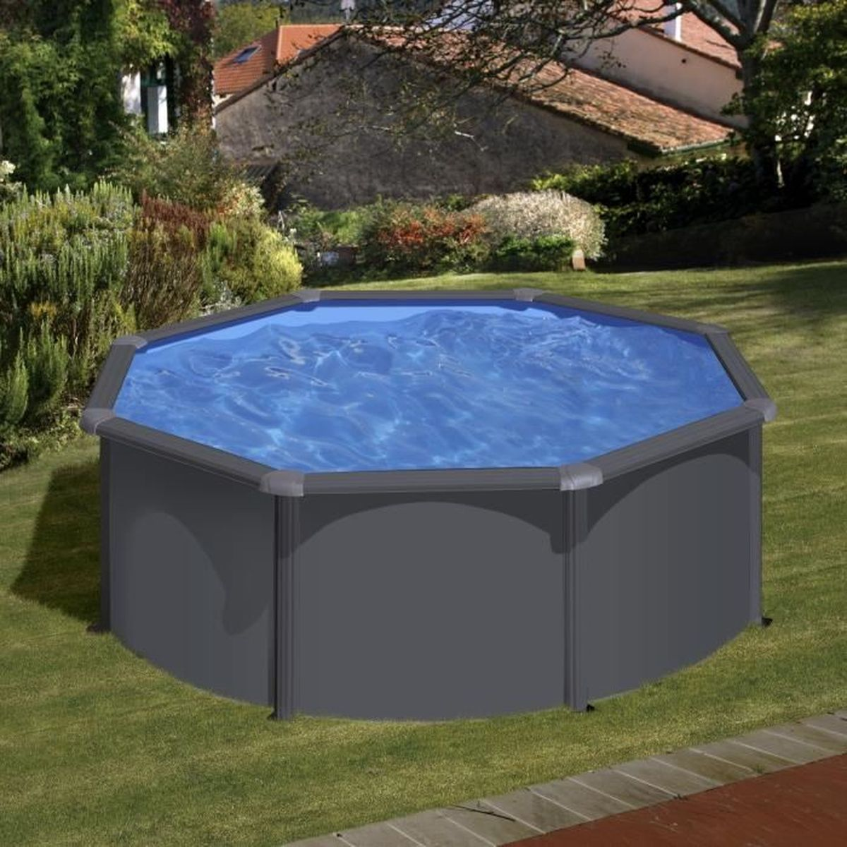 Ein achteckiger Aufstellpool mit blauem Wasser steht auf einem grünen Rasen, umgeben von Bäumen und einem Haus.