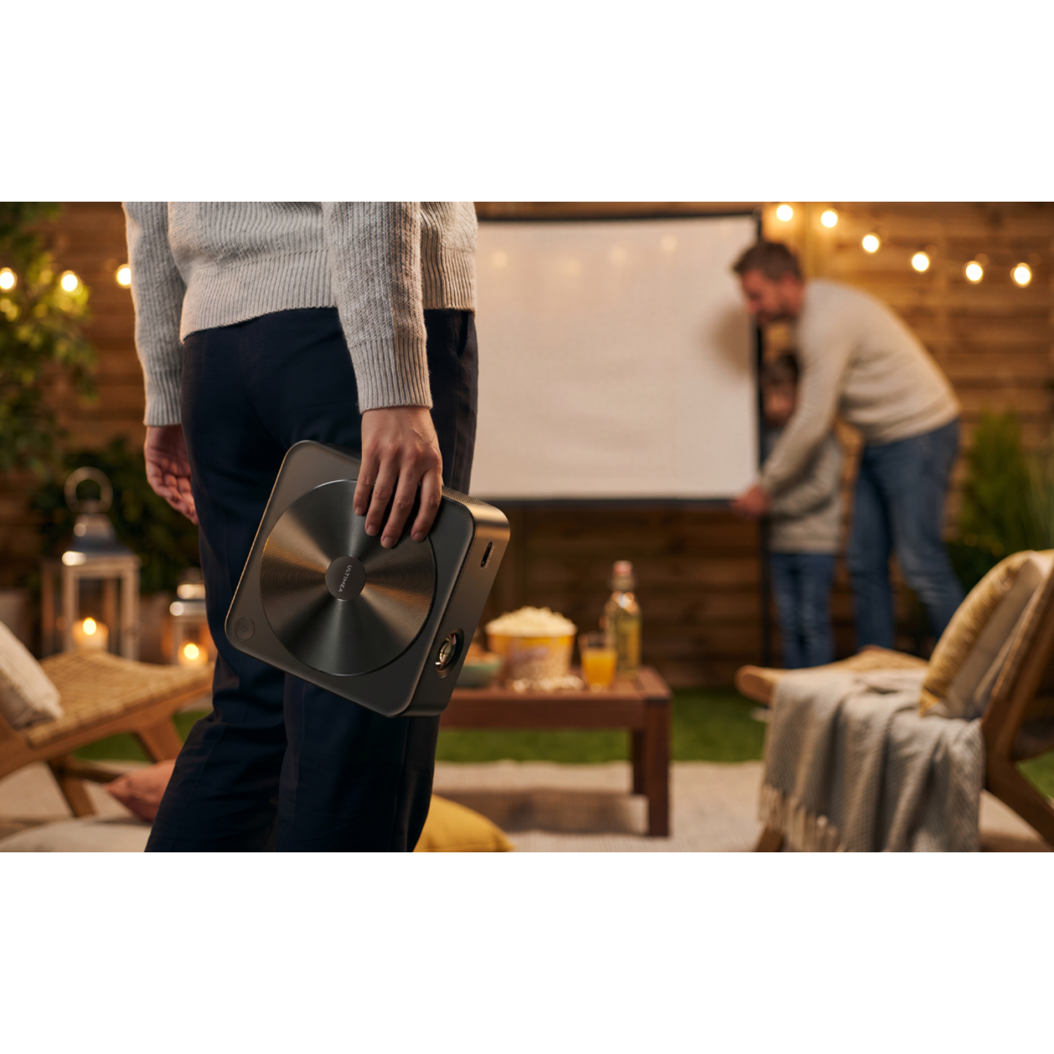 Personne tenant un projecteur lors d'une soirée cinéma en plein air.
