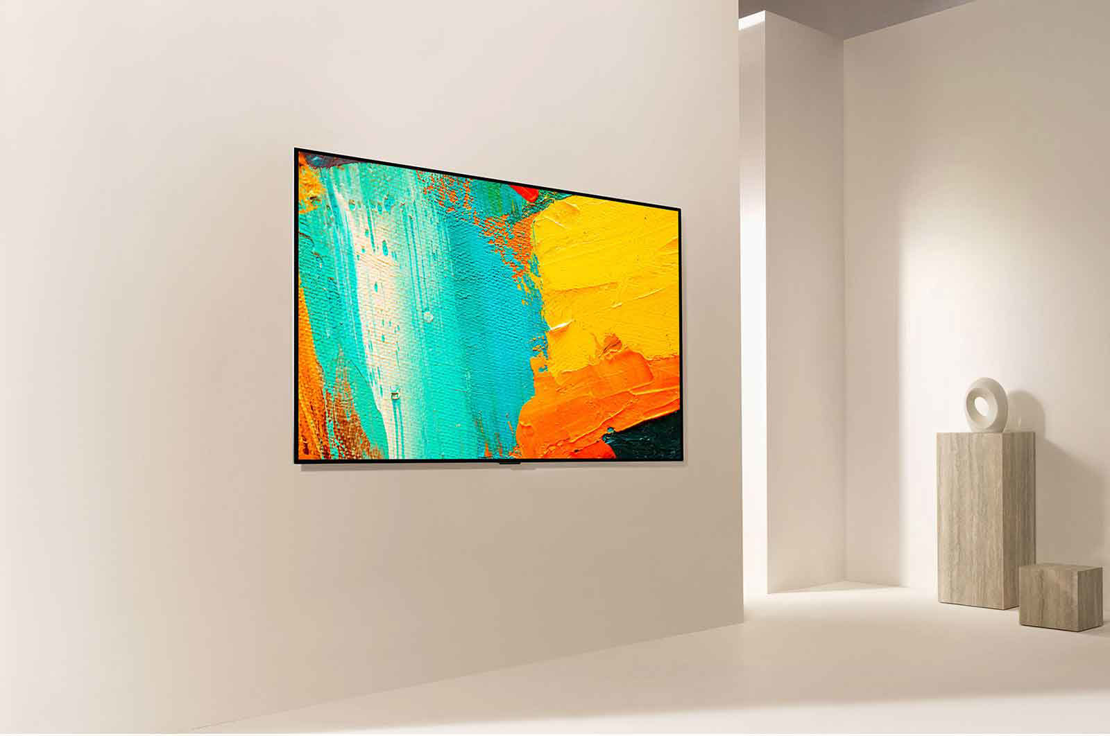 Una TV moderna mostra un'opera d'arte astratta blu, arancione e gialla su una parete bianca.
