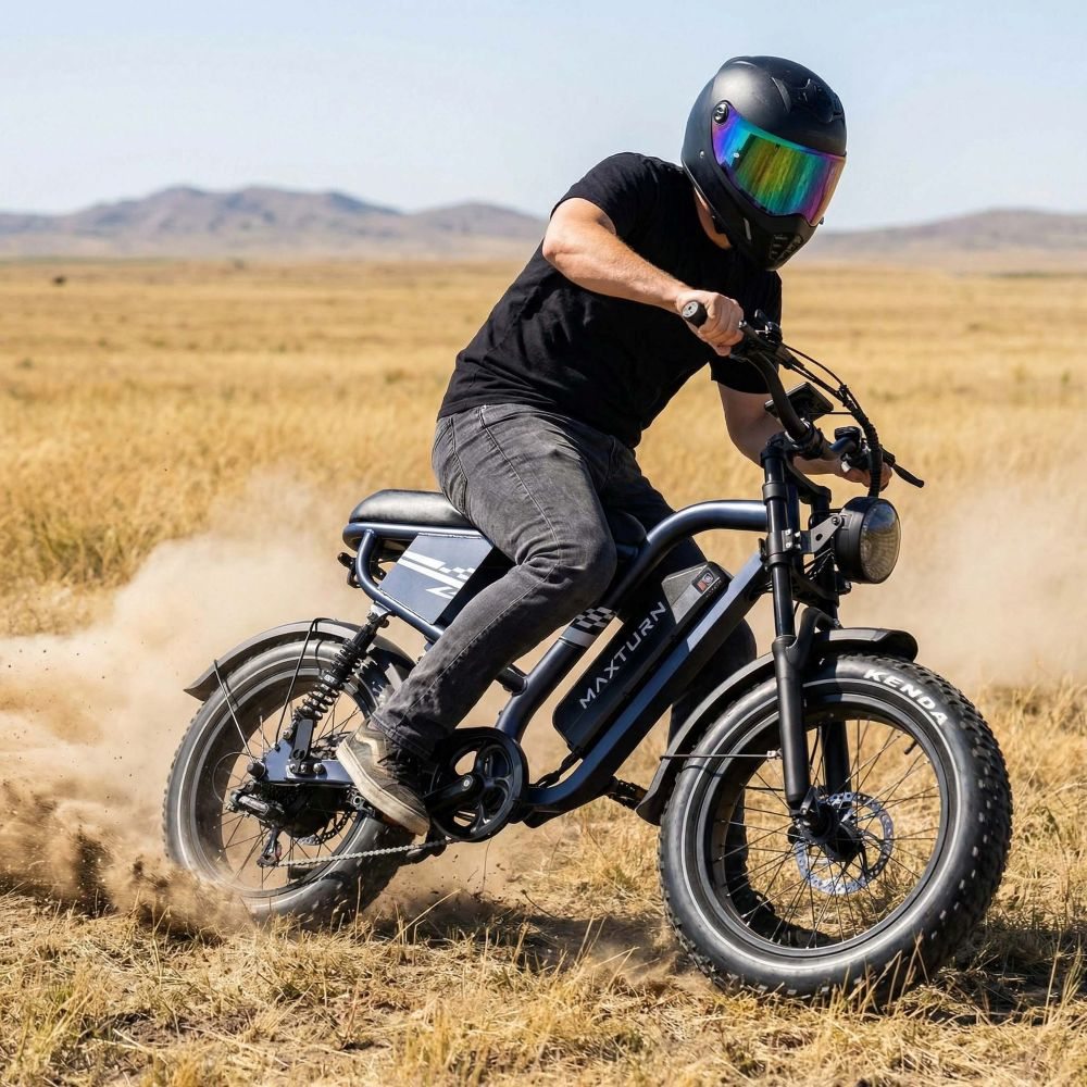 Hombre monta bicicleta eléctrica en paisaje polvoriento con casco y ropa negra.