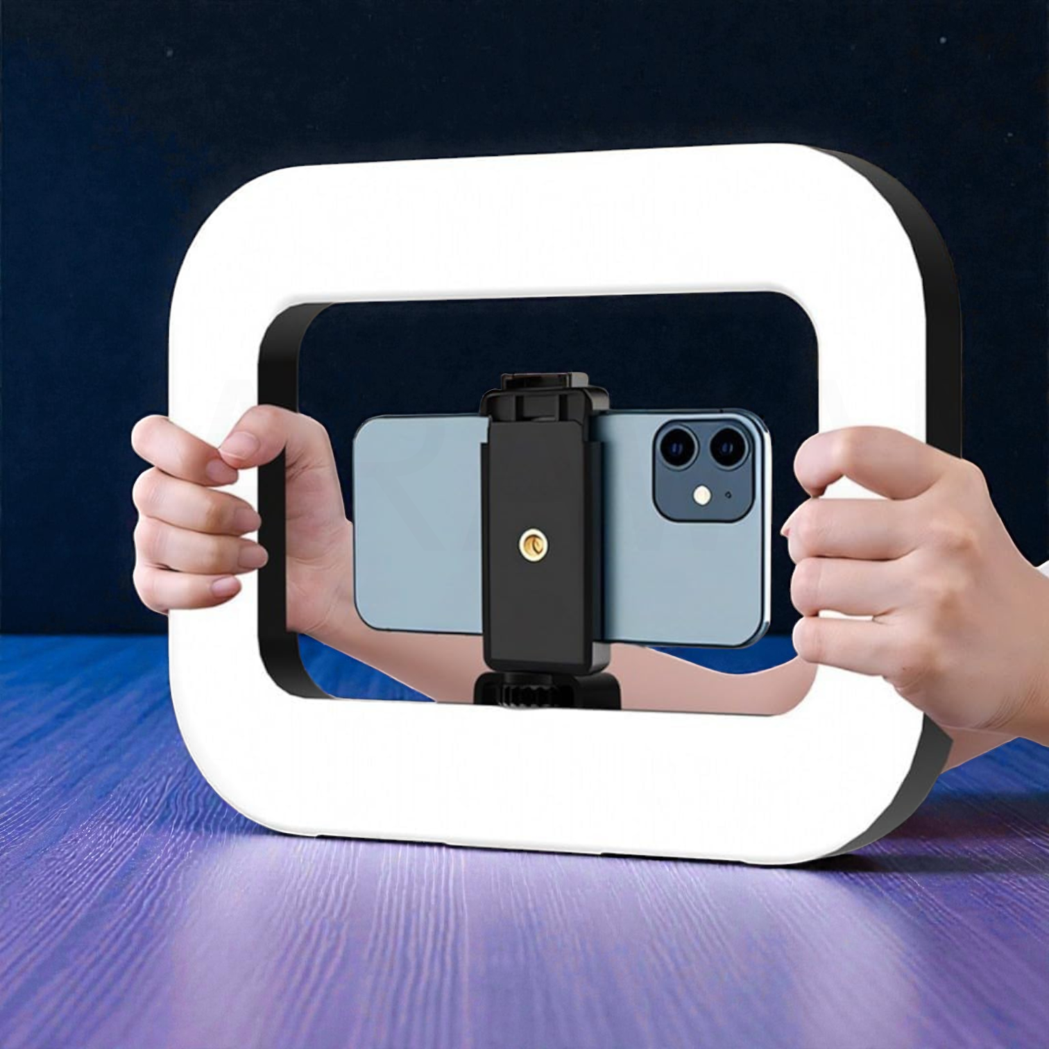 Una persona sostiene un smartphone en una configuración de luz de anillo sobre una mesa de madera morada.