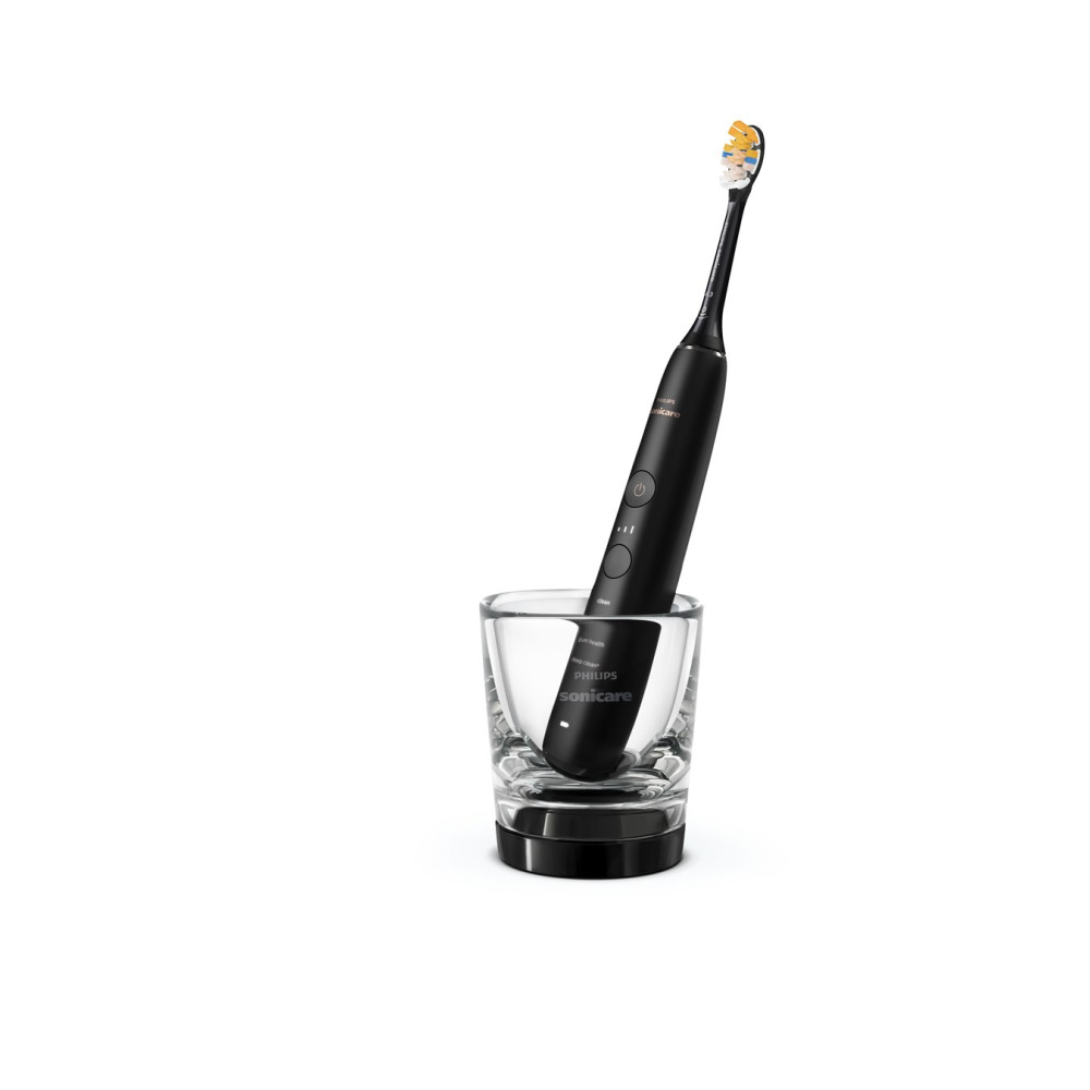 Czarna szczoteczka Philips Sonicare stoi w przezroczystym szklanym uchwycie.