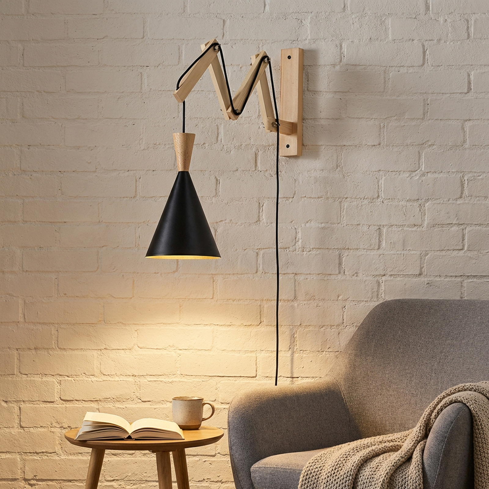 Una lámpara de pared moderna con pantalla negra cuelga sobre una mesa auxiliar con libro y taza.