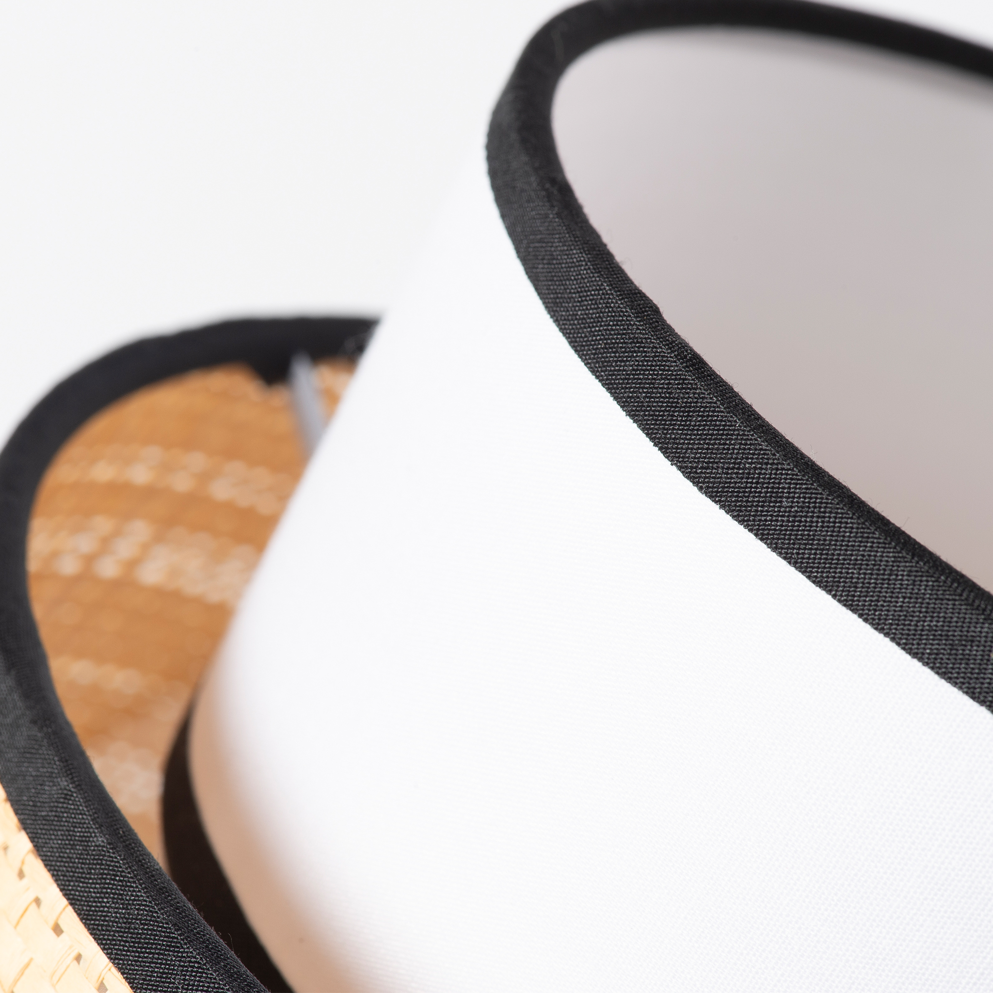 Primer plano de una cesta con borde de tela blanca, ribeteada en negro.