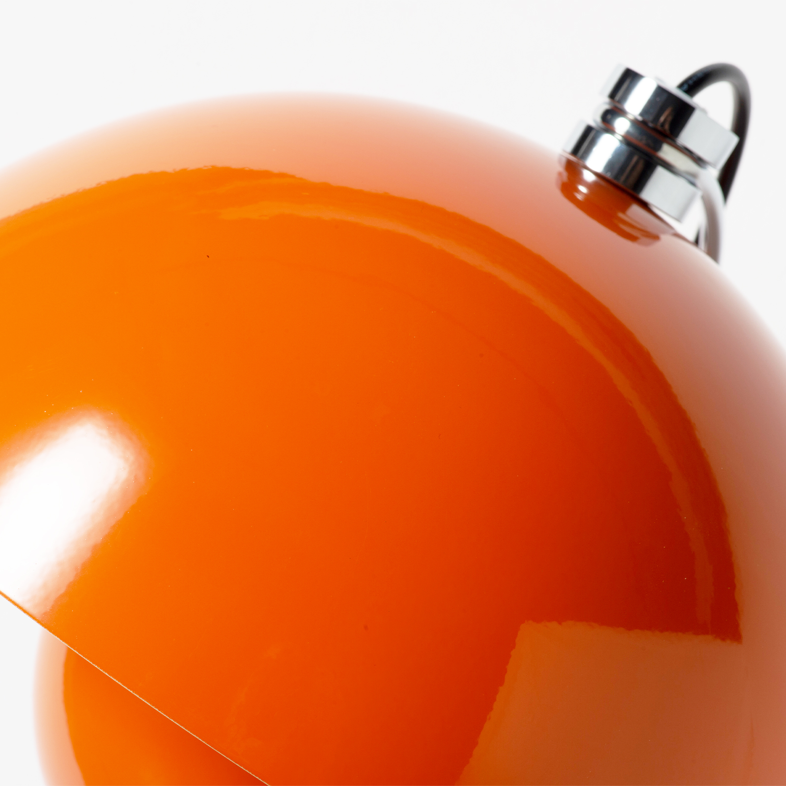 Una esfera naranja brillante con parte superior plateada y cable negro.