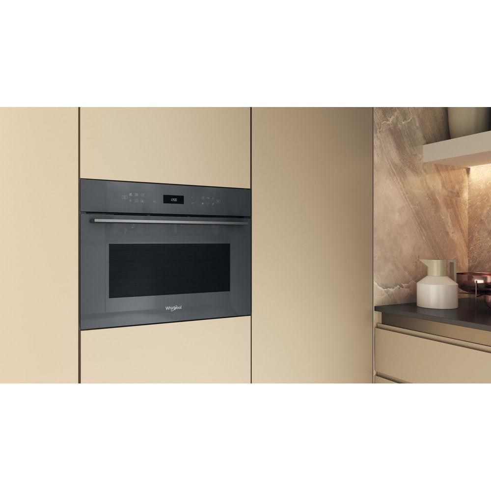 Un forno da incasso moderno con display digitale in una cucina beige.