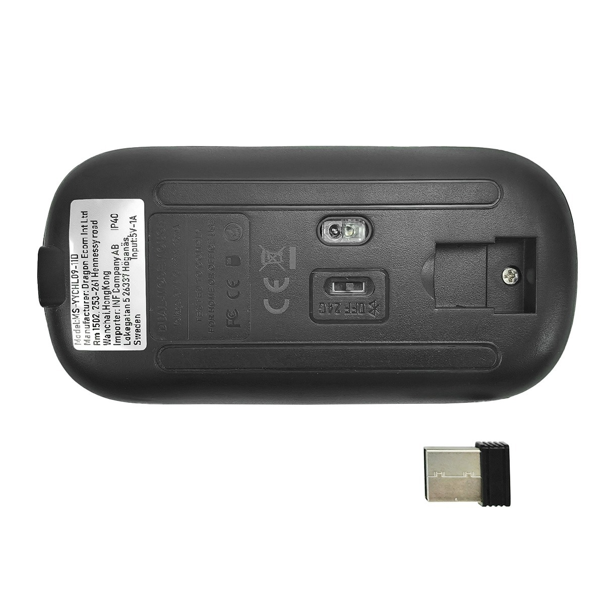Lato inferiore di un mouse nero con adesivo e un dongle USB accanto.