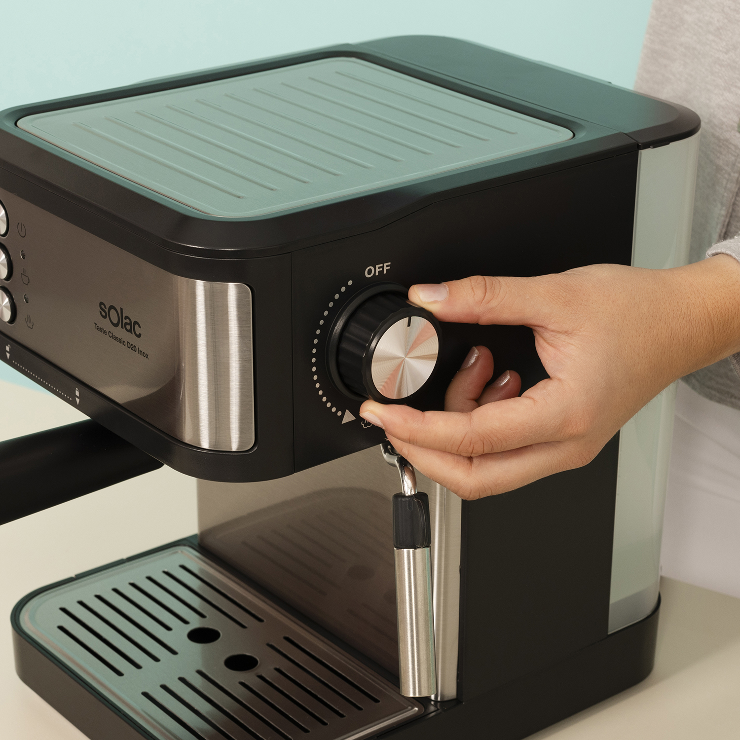 Una mano gira el dial de una cafetera a 