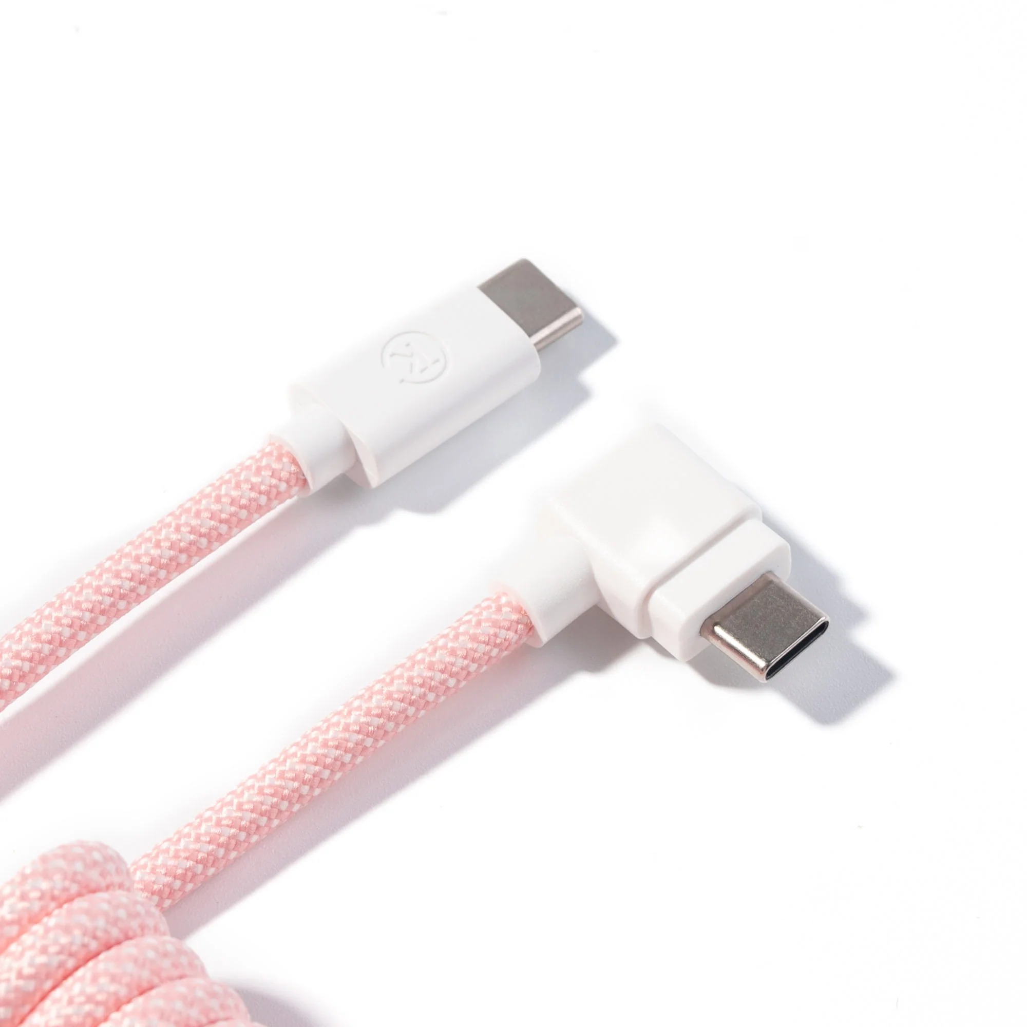 Różowy pleciony kabel USB-C z dwoma białymi złączami na białym tle.
