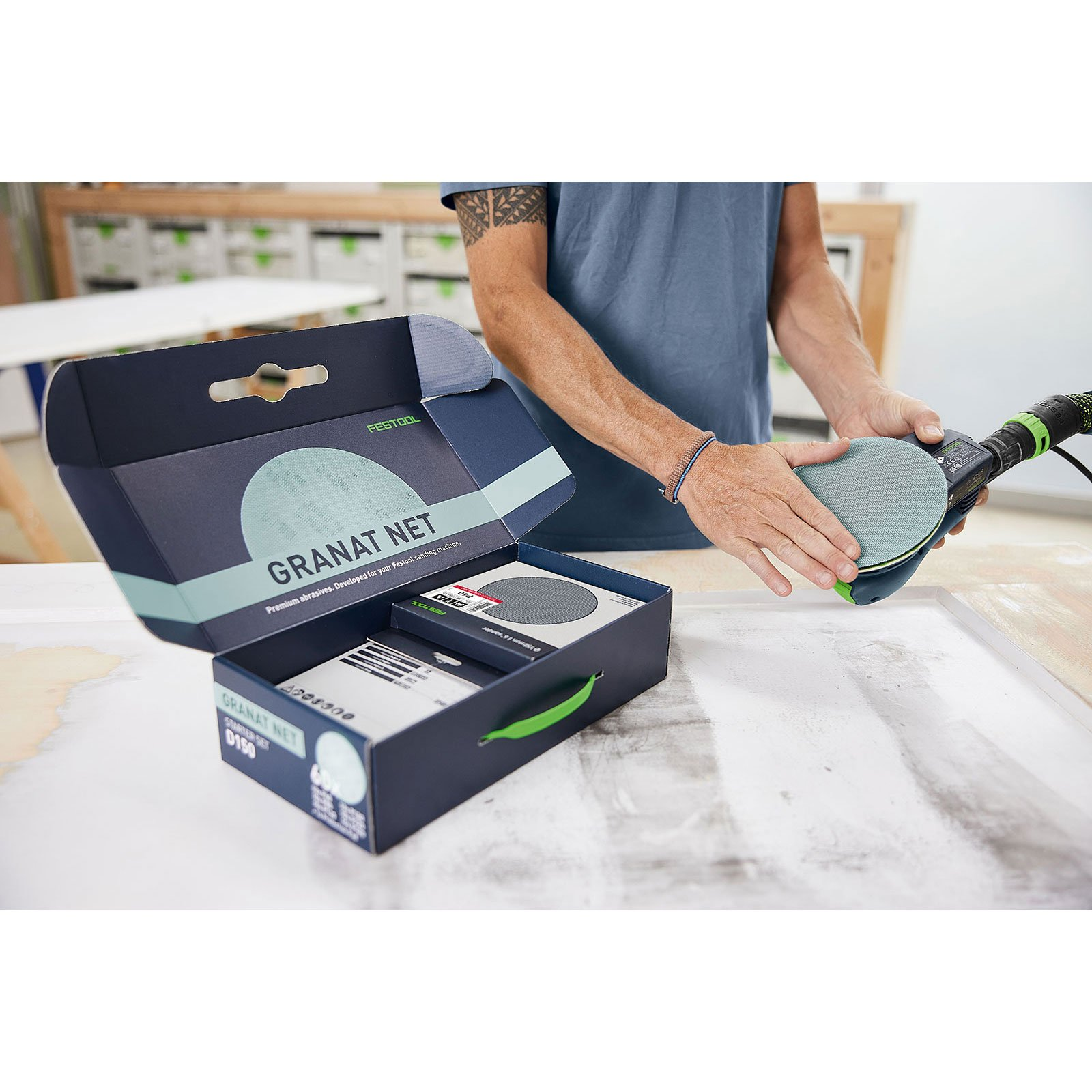 Mann mit Schleifmaschine und Festool Granat Net Karton.
