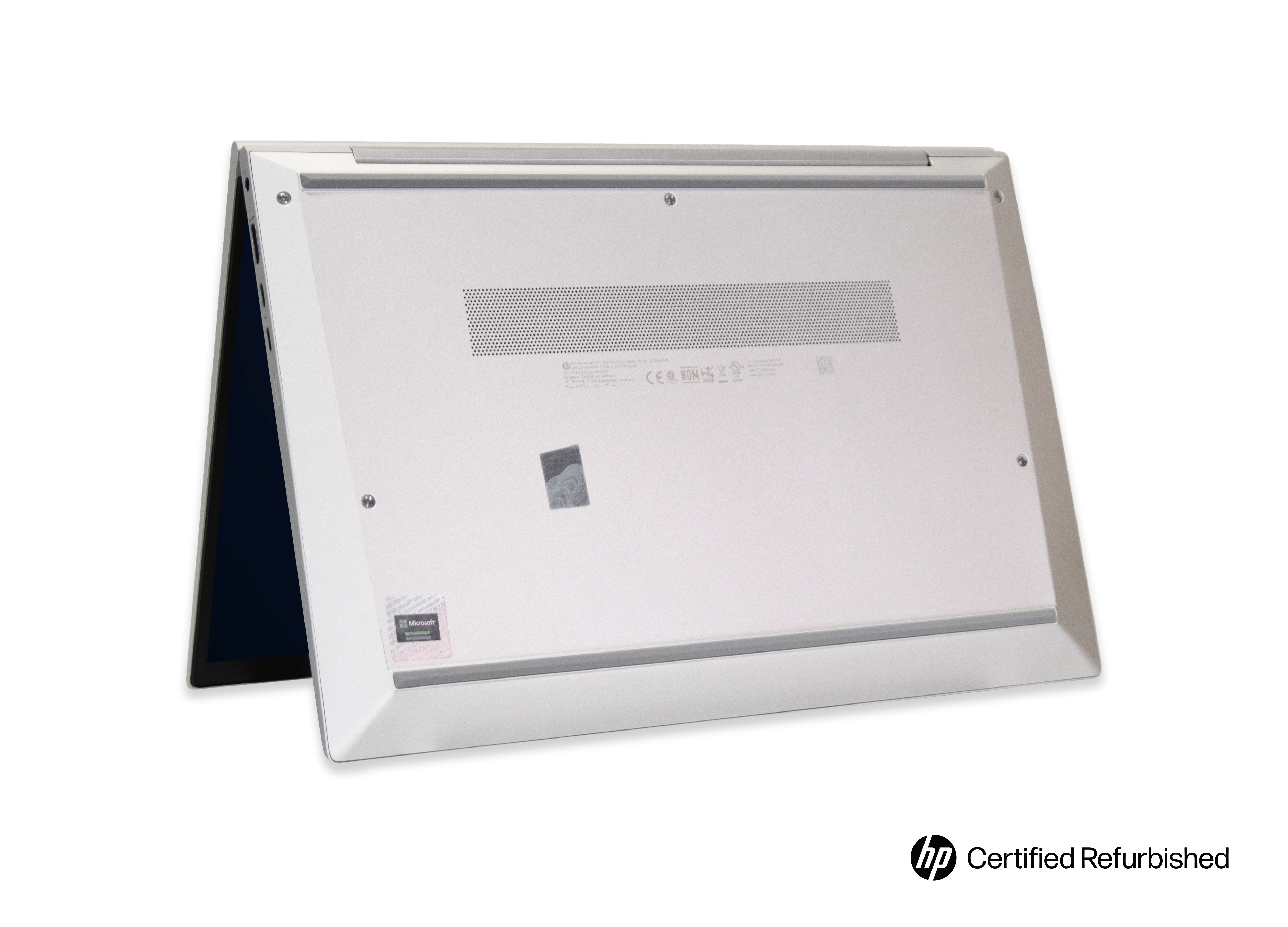 Onderkant van een zilveren HP laptop, licht open, met ventilatieopeningen en stickers.