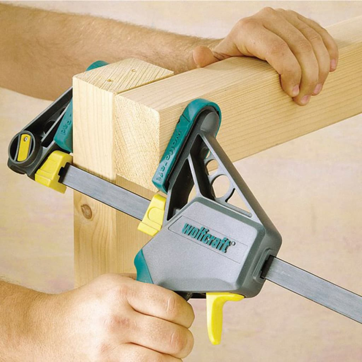 Zwei Holzbalken werden von Klemmzangen zusammengehalten.
