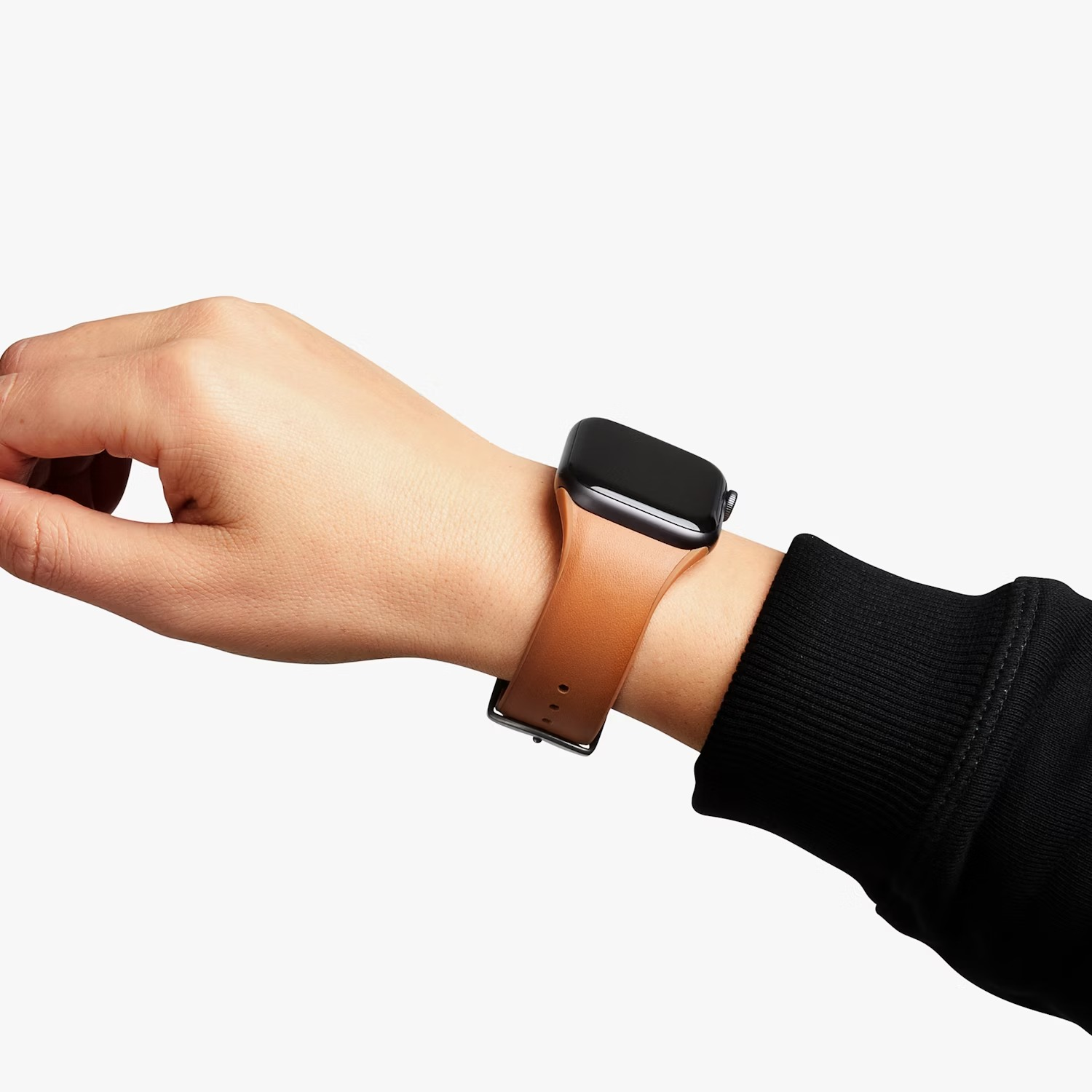 Nadgarstek w brązowym smartwatchu i z czarnym rękawem.
