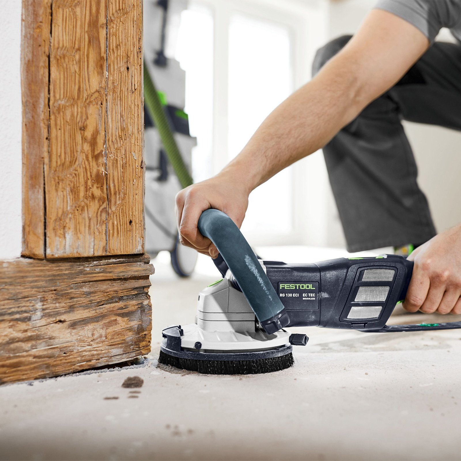 Mann schleift Holz mit Festool RG 130 ECI EC-TEC Schleifmaschine.