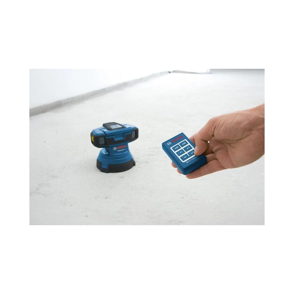 Ein Mann hält eine blaue Fernbedienung neben einem blauen Bosch-Laser-Messgerät auf Beton.