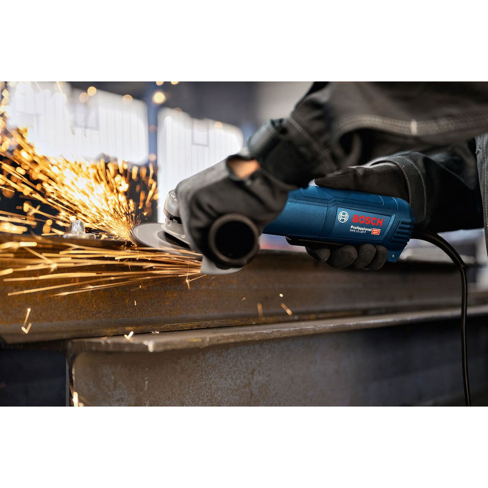 Ein Handwerker mit blauer Bosch-Winkelschleifmaschine bearbeitet Metall, Funken fliegen.