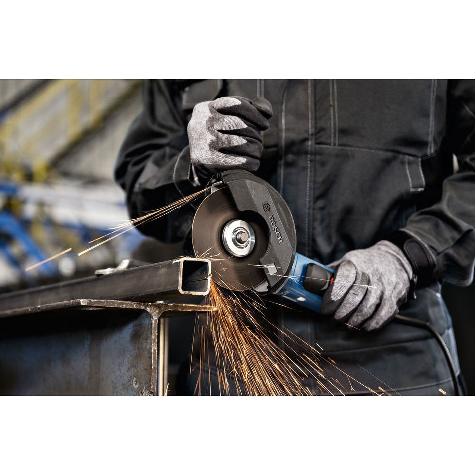 Ein Handwerker mit Handschuhen schneidet mit einem Winkelschleifer Metall.