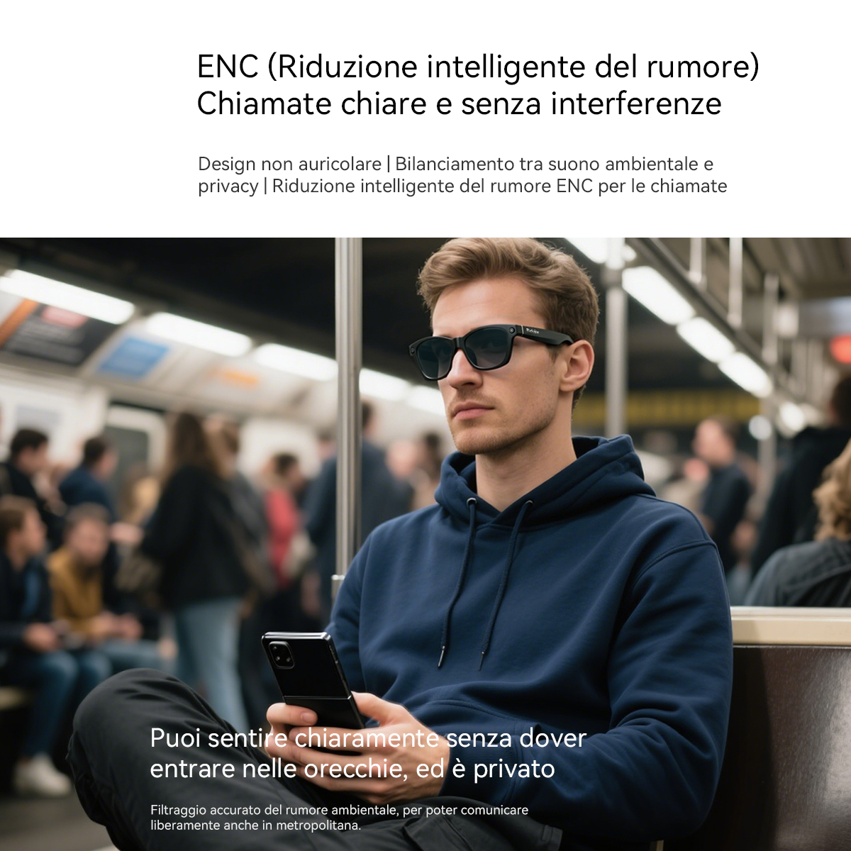 Un uomo in metropolitana tiene il telefono, con occhiali da sole e cuffie. Sfondo sfocato.