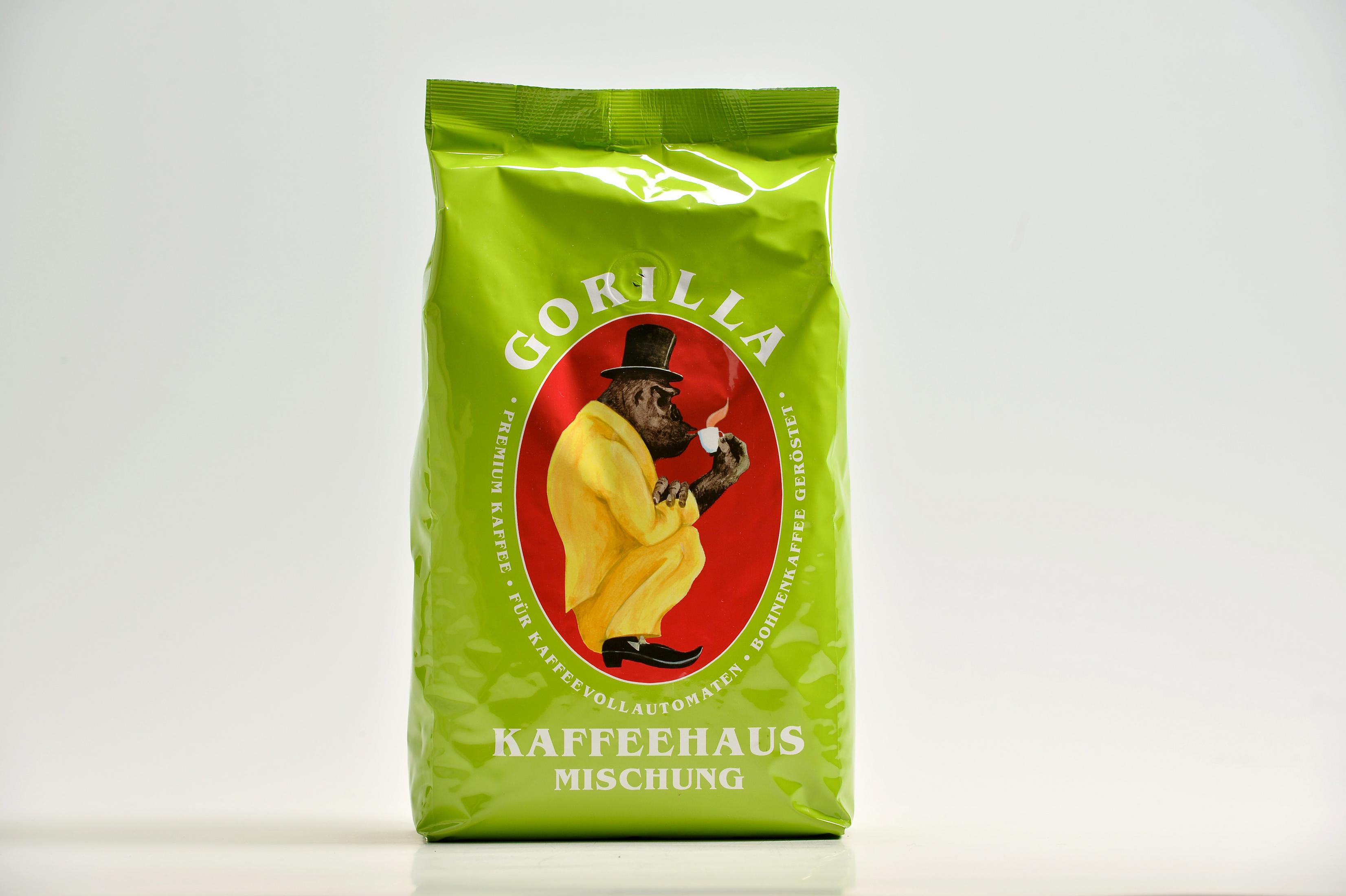 Grüner Kaffeebeutel mit Gorilla im gelben Anzug, der eine Tasse trinkt.