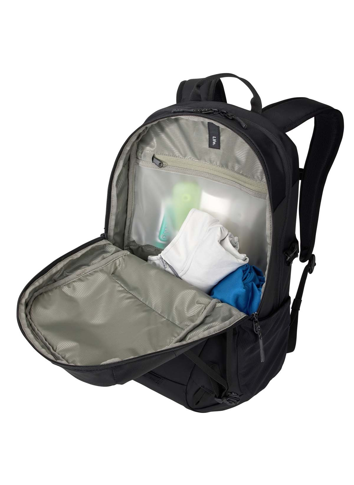 Ein schwarzer Rucksack mit geöffnetem Hauptfach, darin weiße und blaue Kleidung.
