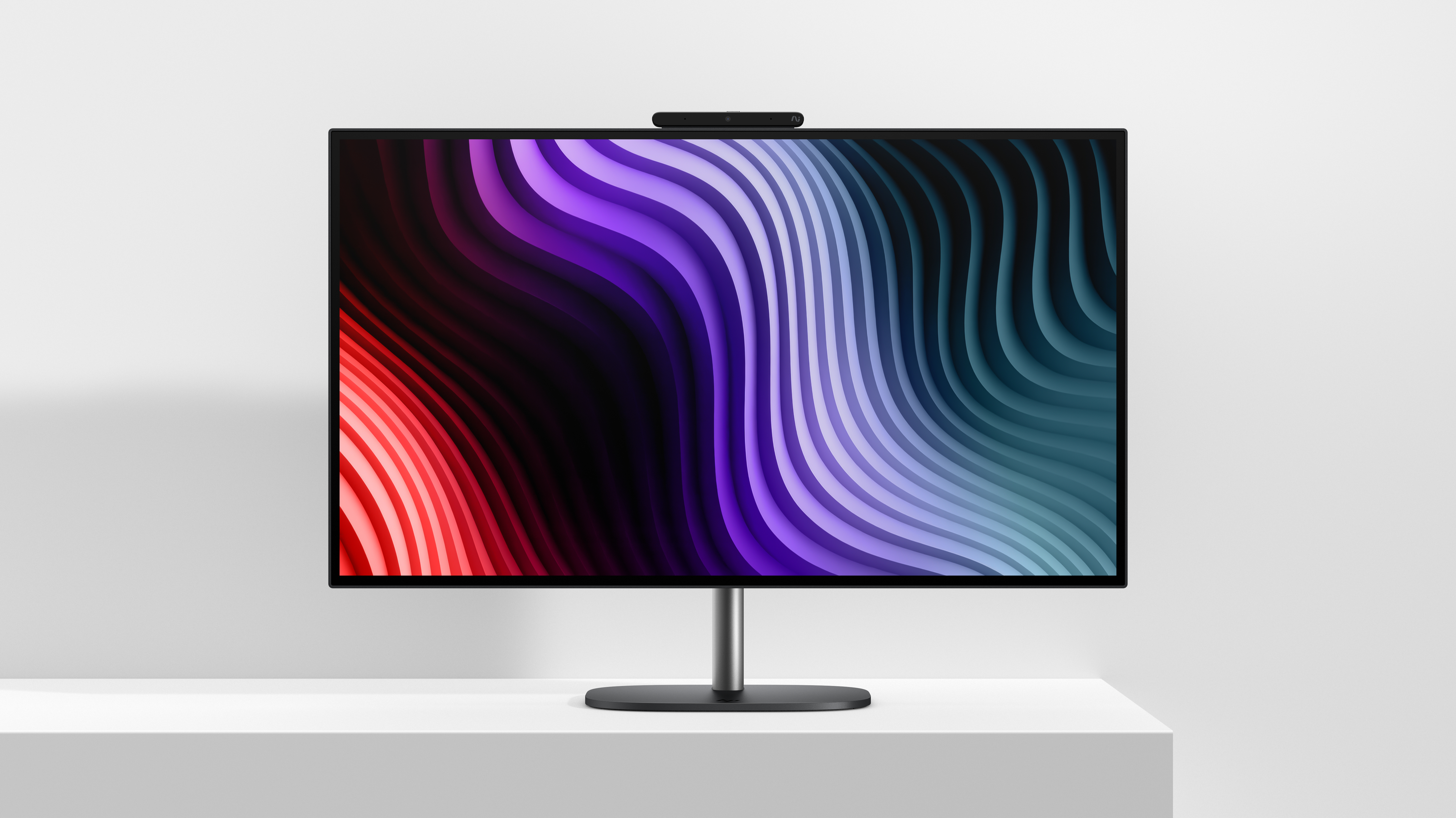 Een strakke monitor op een witte standaard toont een kleurrijk abstract golvend patroon in rood, paars en cyaan.
