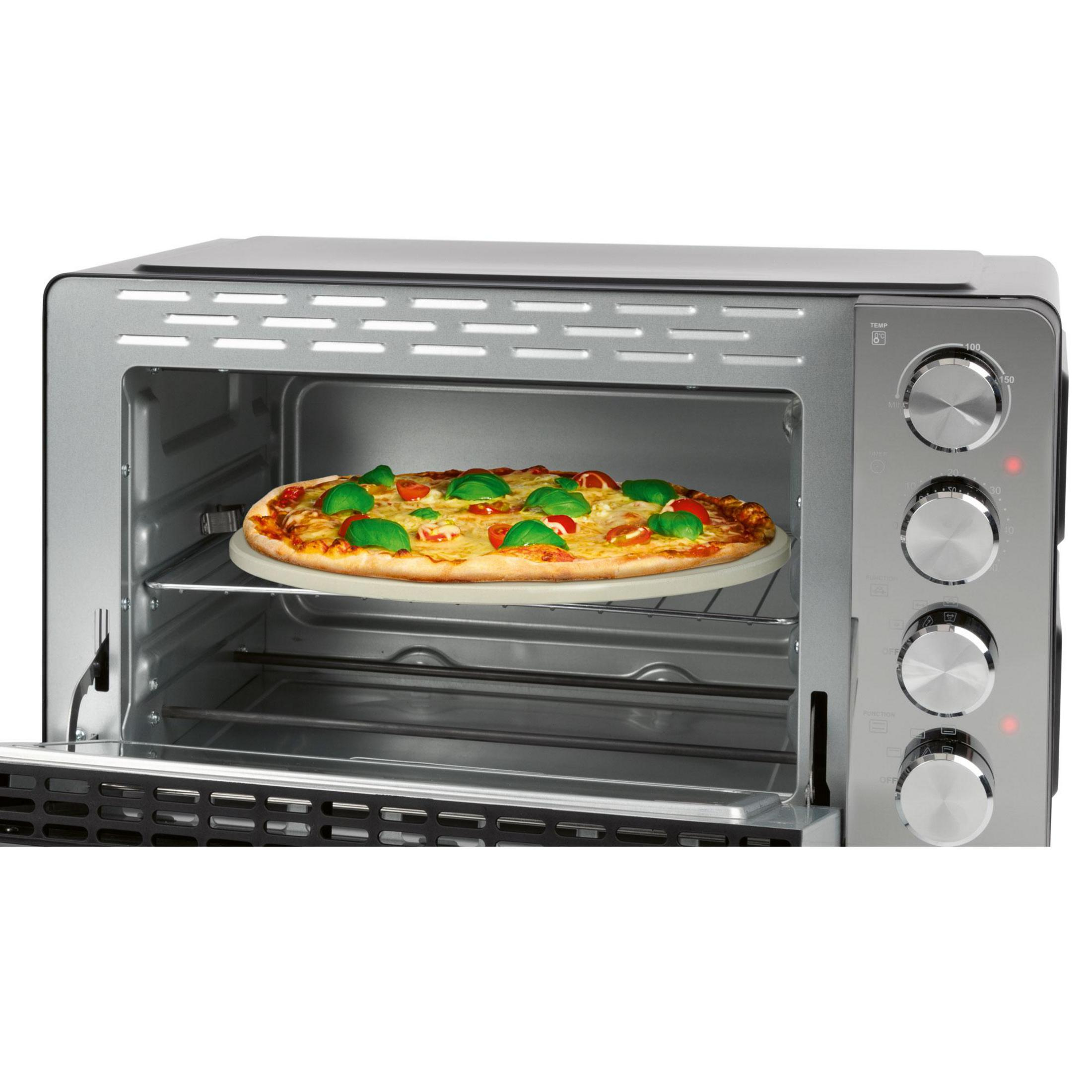 Una pietra per pizza rotonda con una pizza condita con formaggio, pomodori e basilico all'interno di un tostapane.