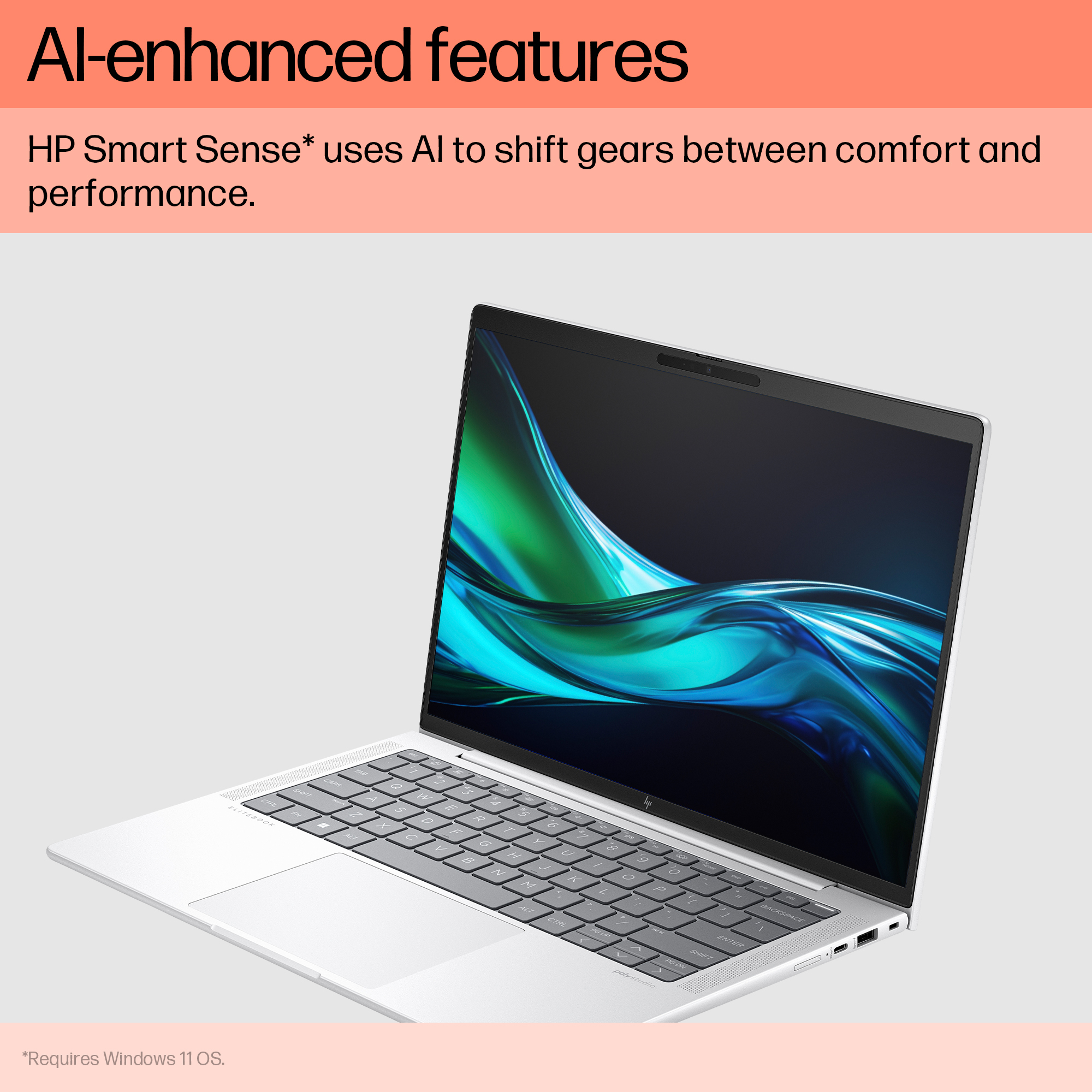 Un laptop argentato con tastiera retroilluminata e grafica astratta blu e verde sullo schermo.