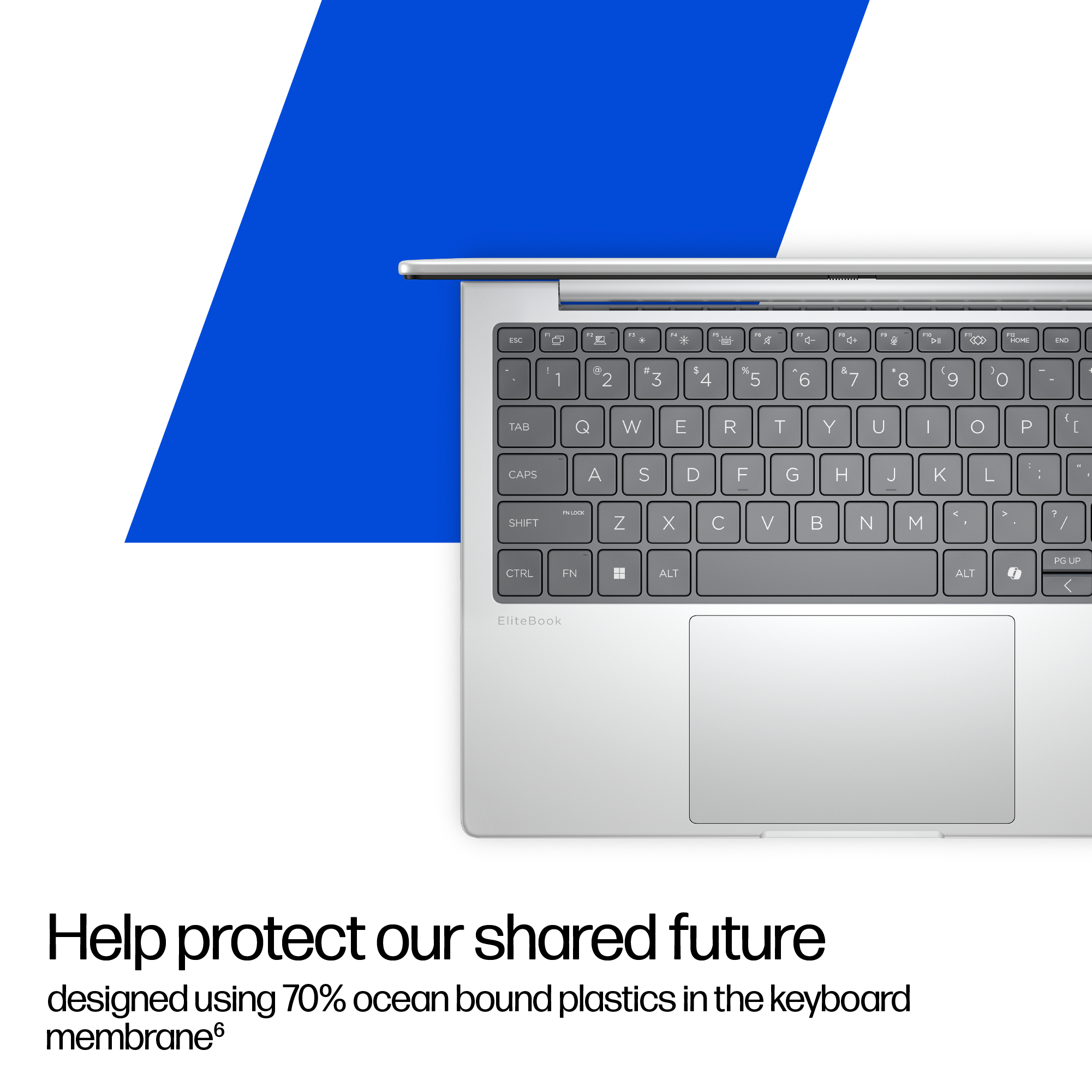 Srebrny laptop z klawiaturą i touchpadem, niebiesko-białe tło.