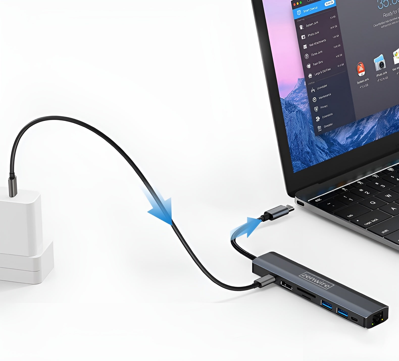 Un hub USB-C grigio è collegato a un laptop. Un cavo porta a un caricatore bianco.