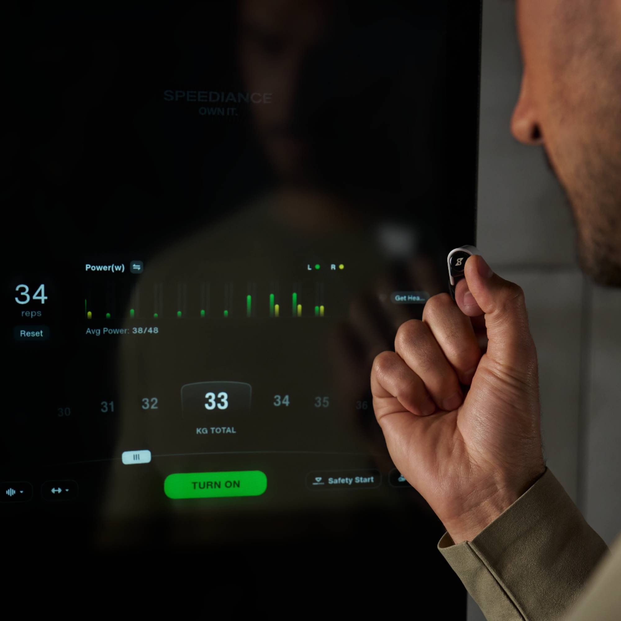 Mannelijke hand gebruikt een smart device met vermogensstatistieken en een aan-knop.