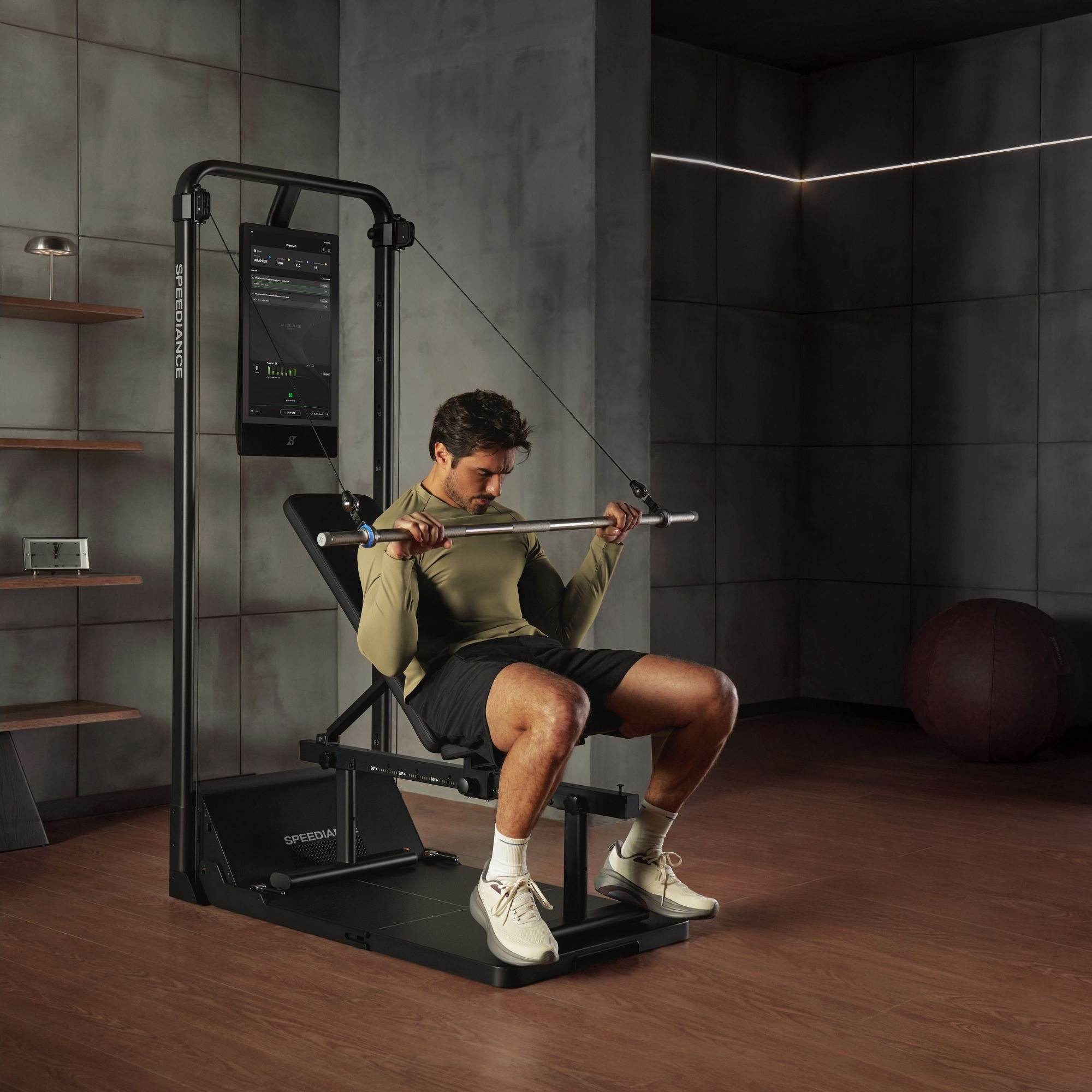 Een man traint op een fitnessapparaat, houdt een stang vast en zit op een bankje.