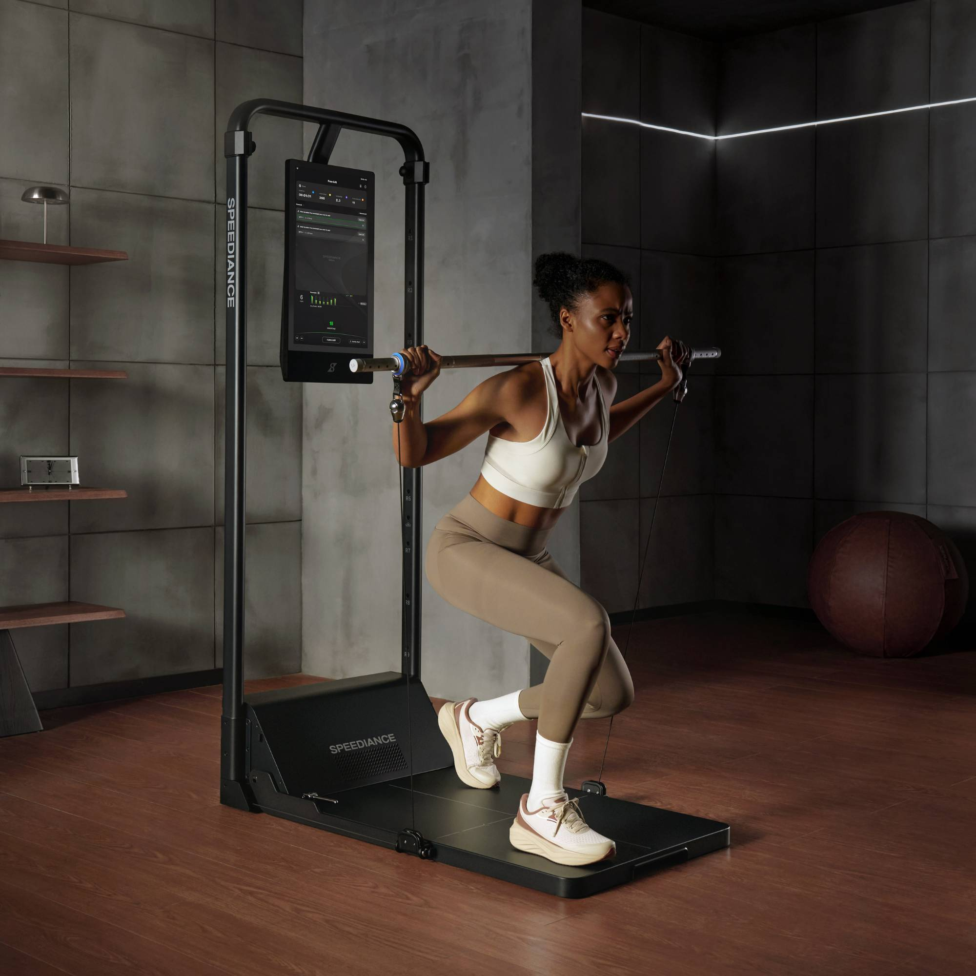 Vrouw doet squats met een halter op een trainingsapparaat met scherm.