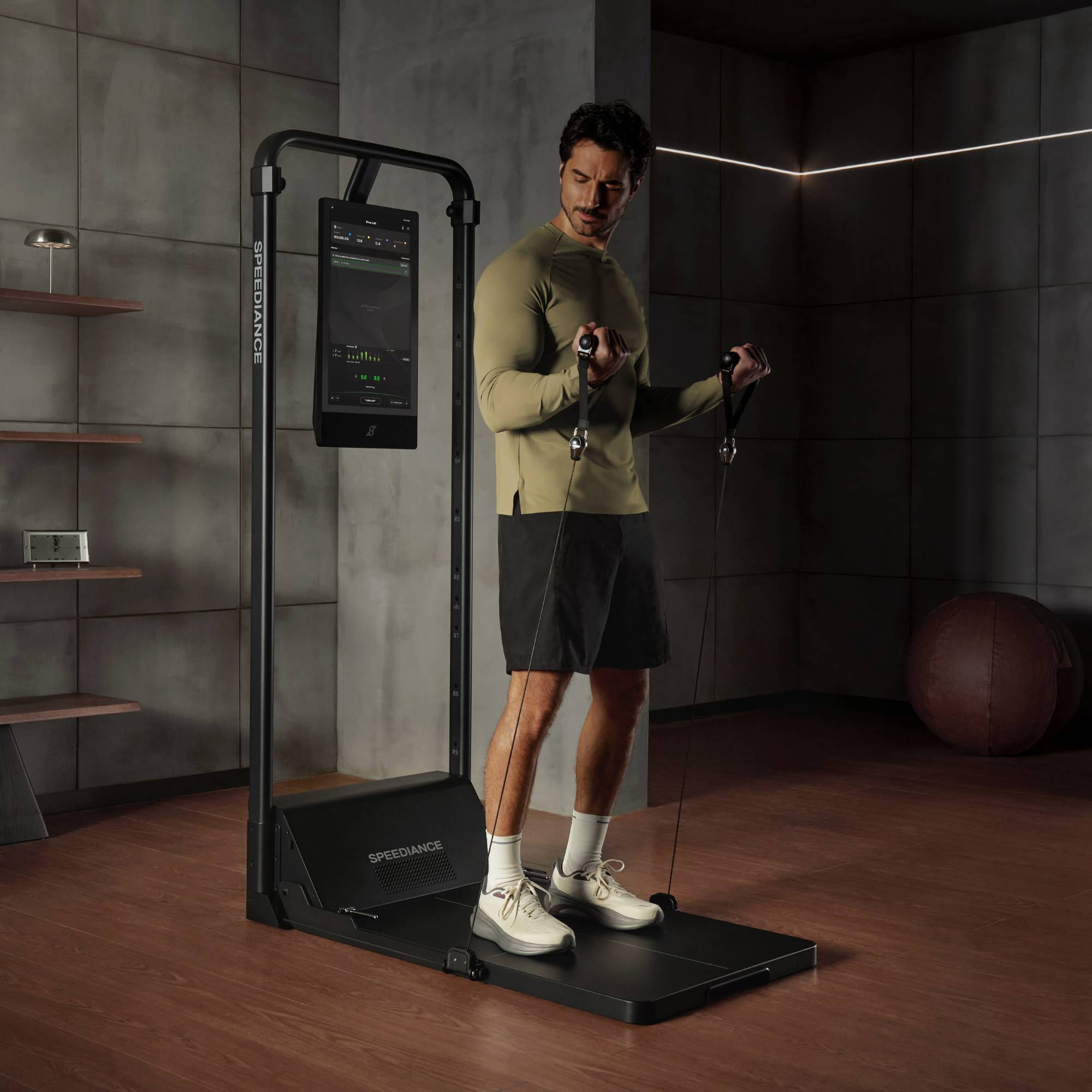 Een man oefent met een weerstandsband op een fitnessapparaat met scherm.