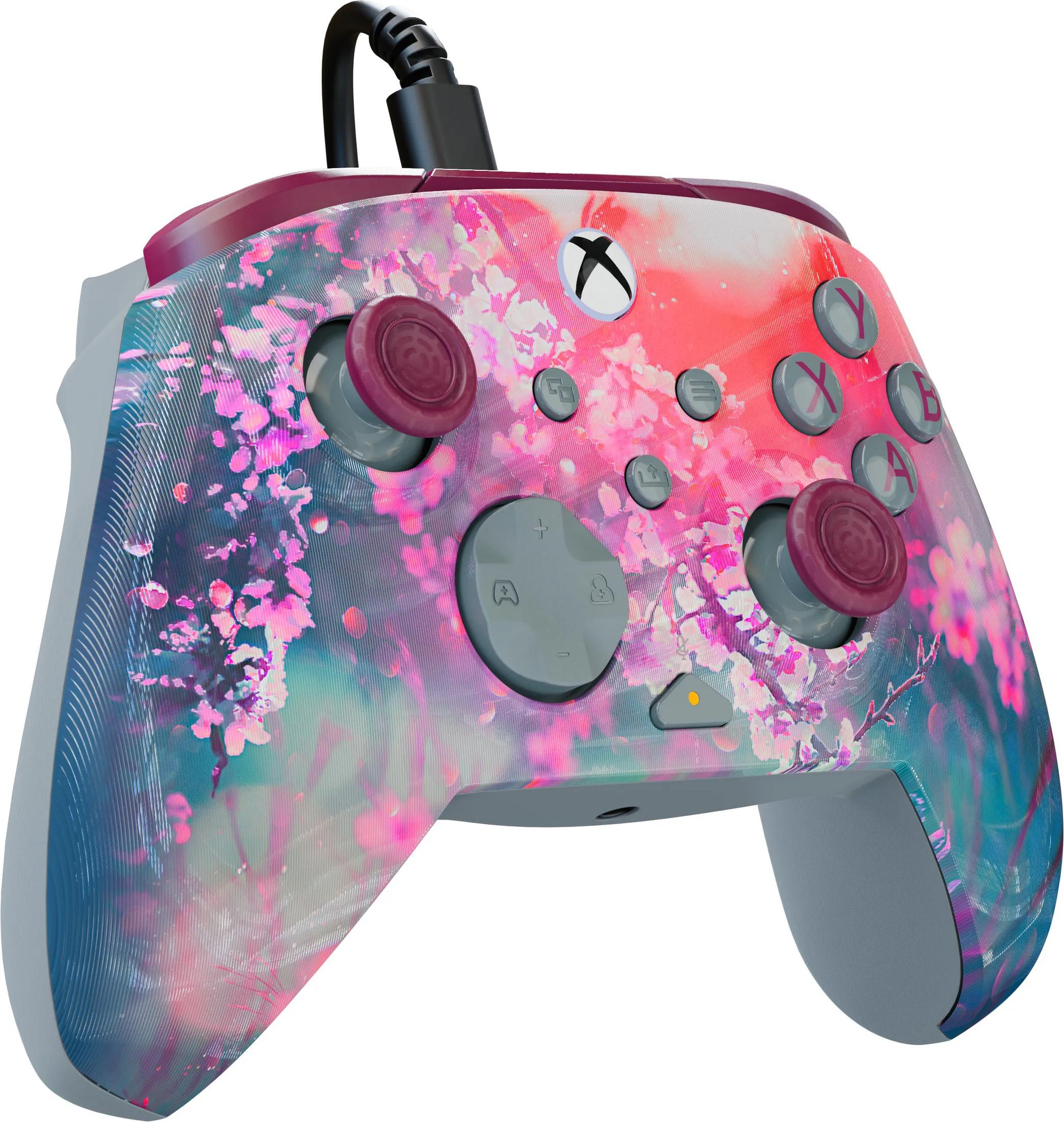 Ein Controller mit kirschblütenmuster, der mit einem schwarzen Kabel verbunden ist.